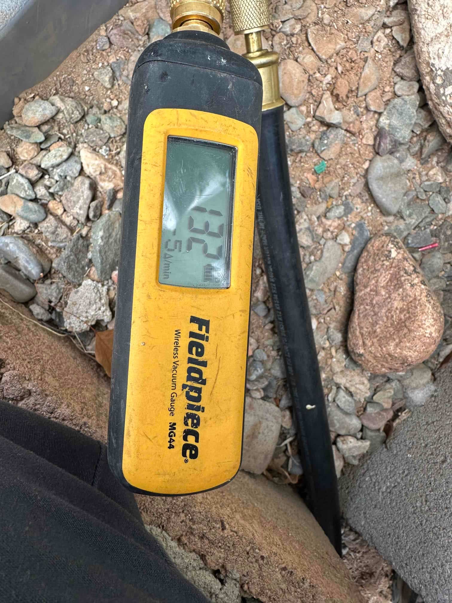 Digital vacuum gauge connected to the system shows a deep vacuum achieved during evacuation prior to refrigerant charging.