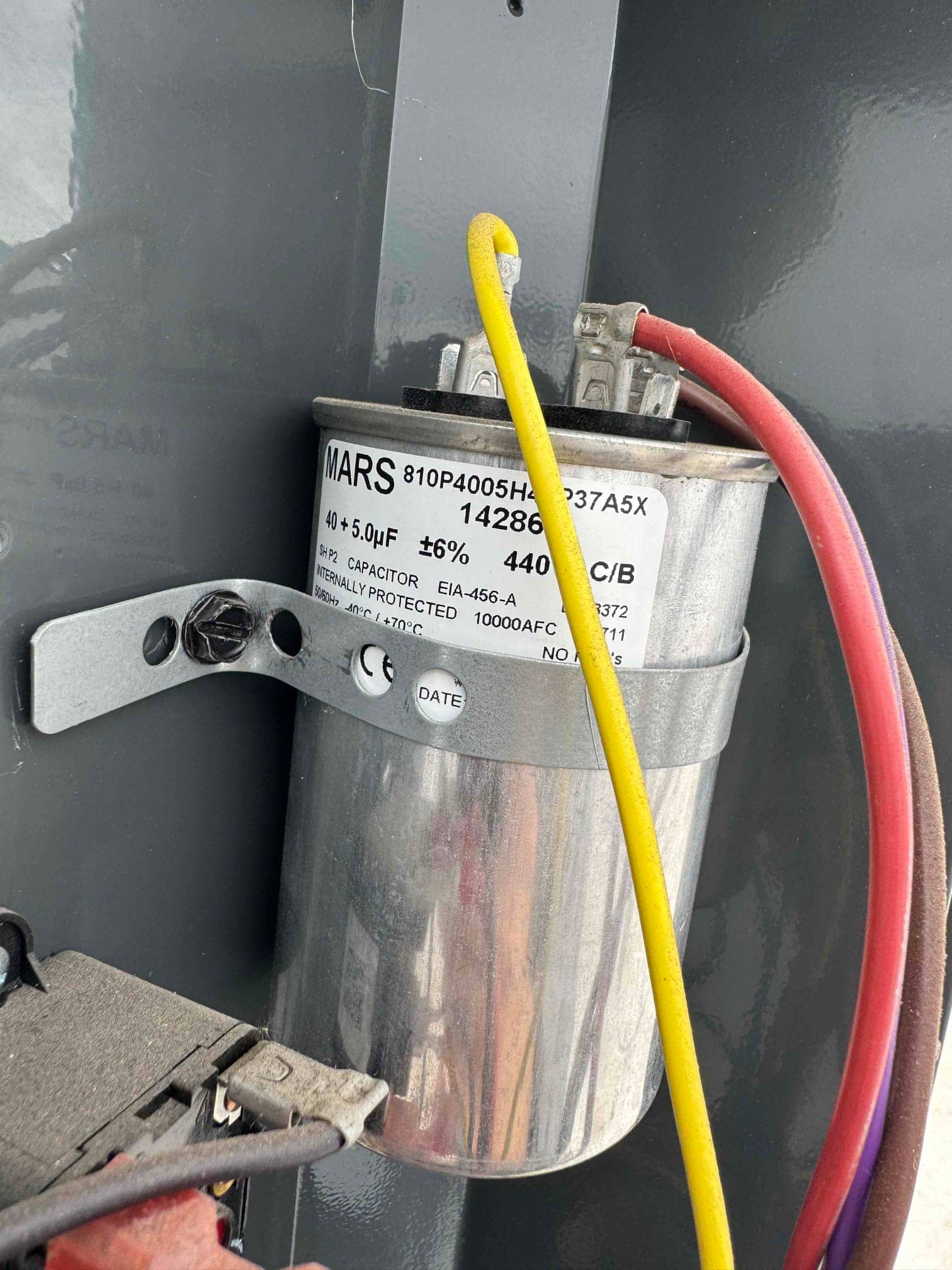 Dual-run capacitor mounted inside the condenser panel, labeled 45 + 5 μF ±6% at 440 VAC, with connected yellow and brown wires.