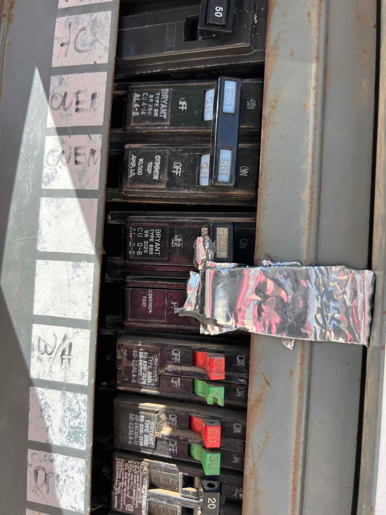 Electrical panel with multiple circuit breakers labeled for household circuits, showing several breaker ratings including 50, 30, and 20 amperes.