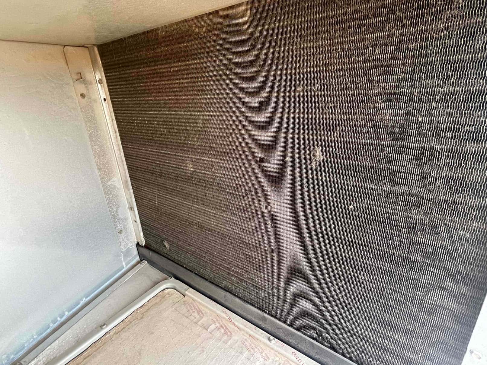 Evaporator coil surface inside the air handler showing dust accumulation on fins before a super cleaning service.