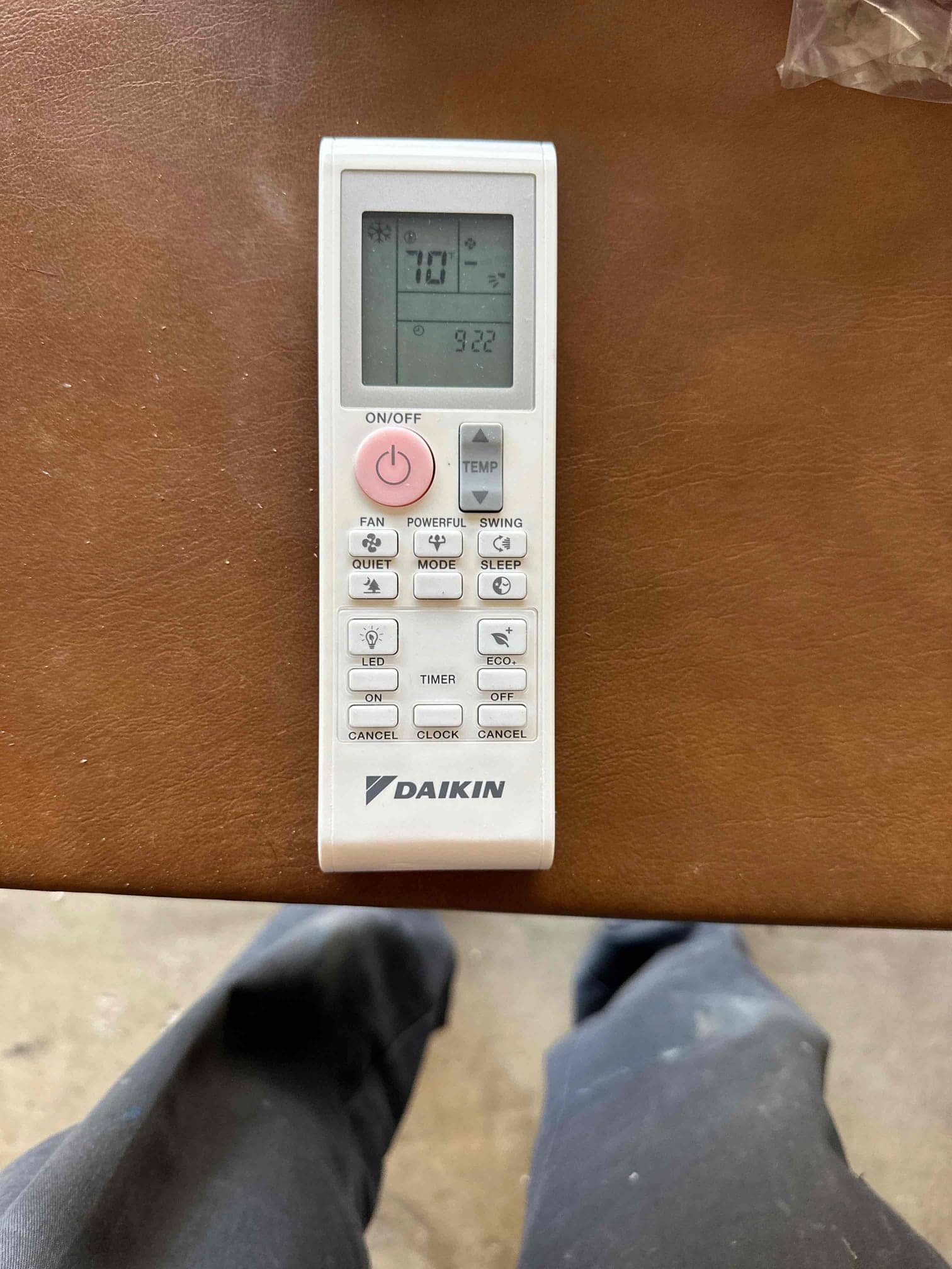 Mini-split remote control set to cooling mode at 70°F displayed on a work surface during installation.
