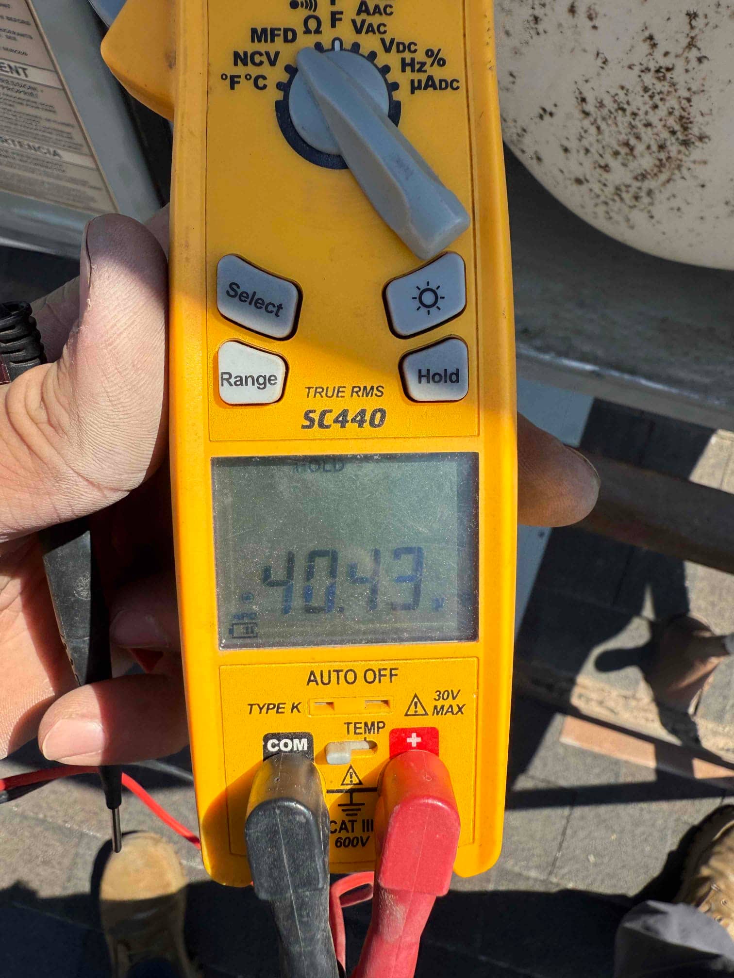 Multimeter measures capacitance at 40.43 μF with test leads connected across a capacitor during diagnostic evaluation.