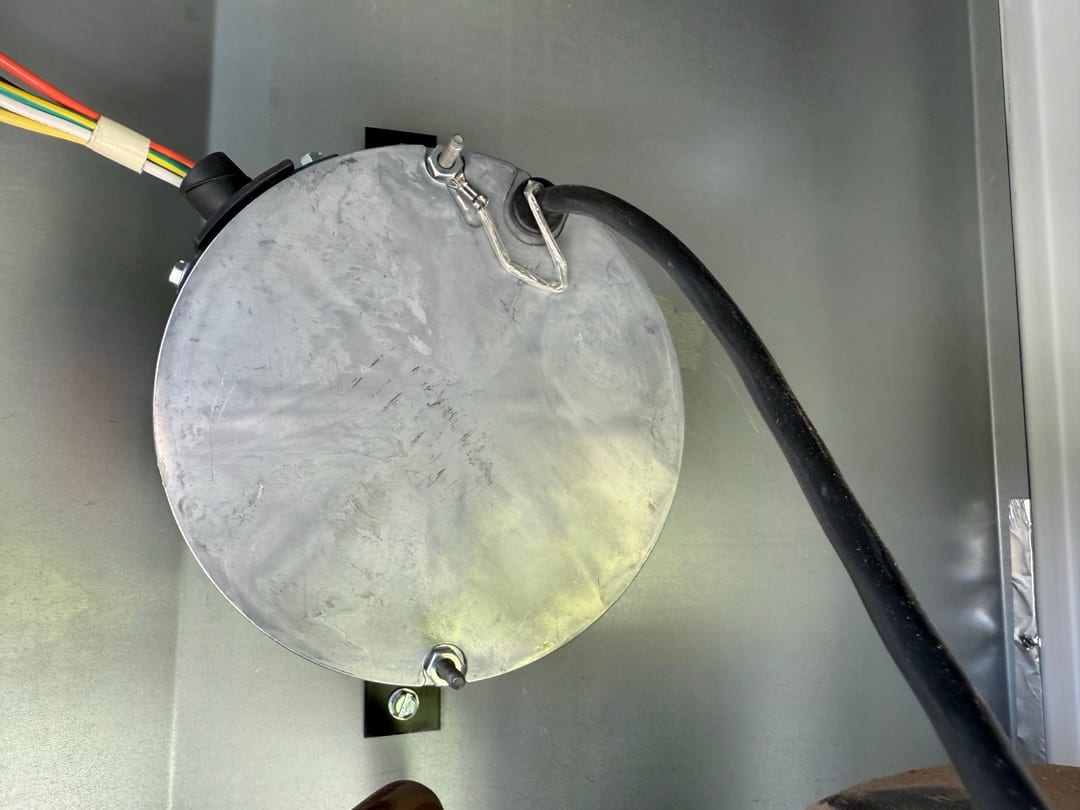 New condenser fan motor installed with wiring harness and conduit secured inside the outdoor unit housing.