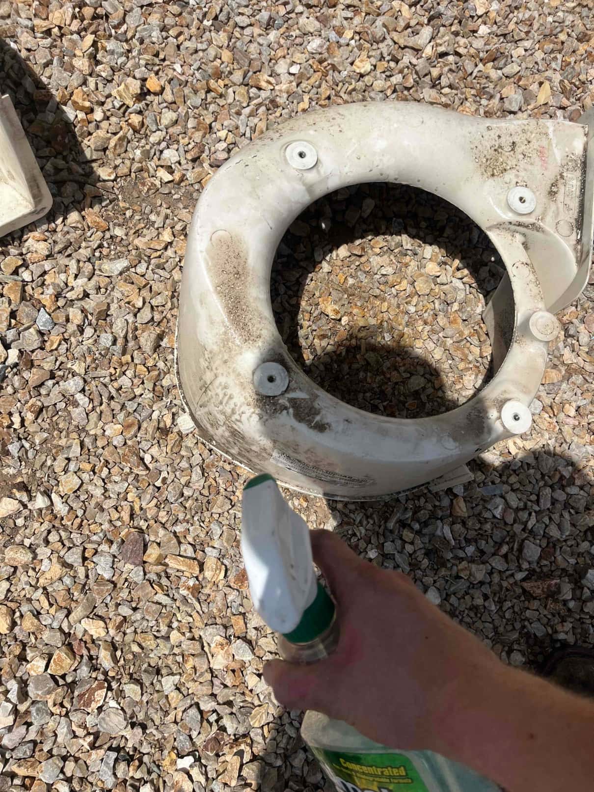 Technician sprays cleaner onto a dirty condenser fan shroud before reassembly as part of a super clean service.