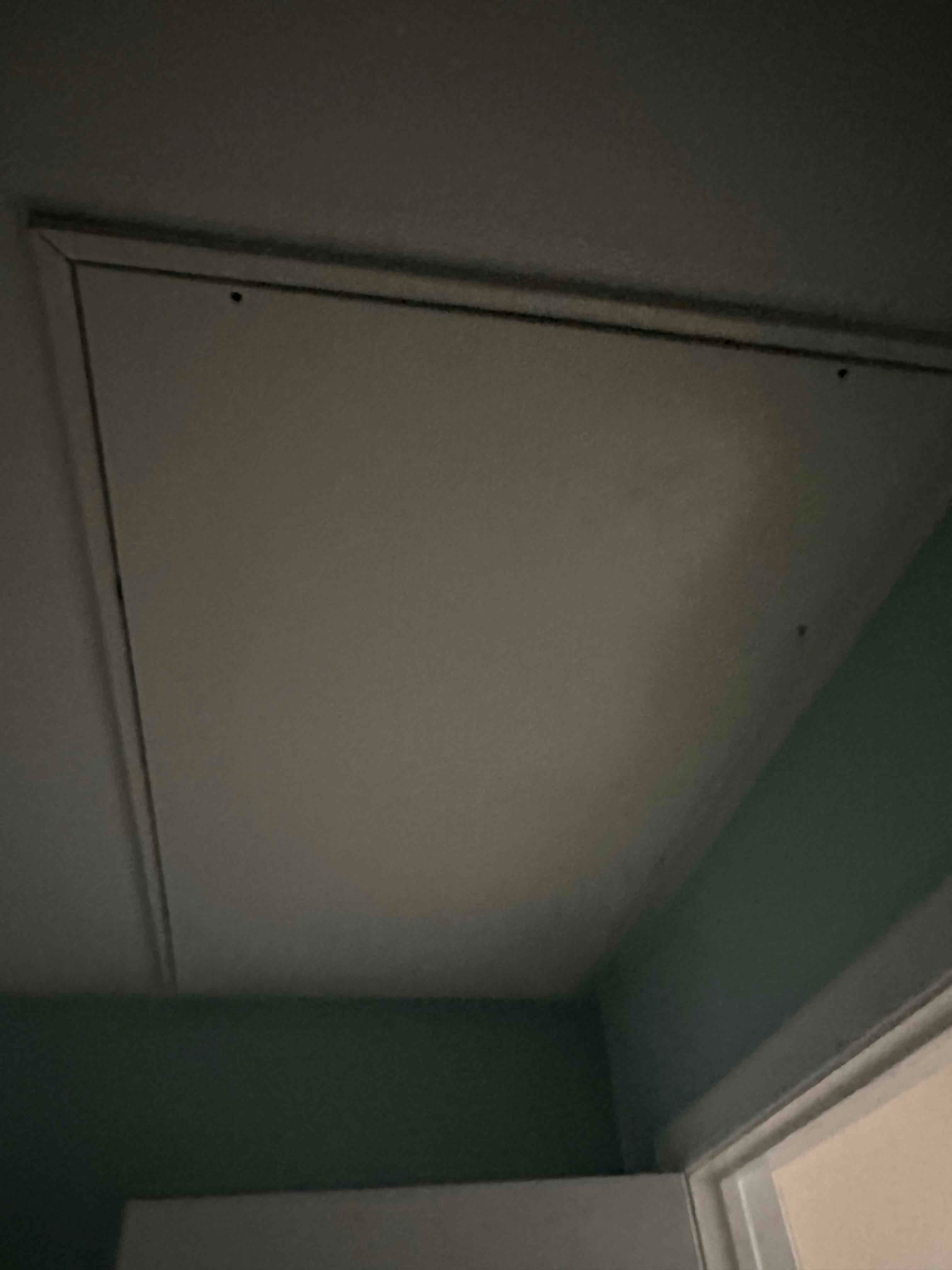 Ceiling attic access panel near a doorway, providing entry to the indoor installation area for HVAC equipment and ductwork.