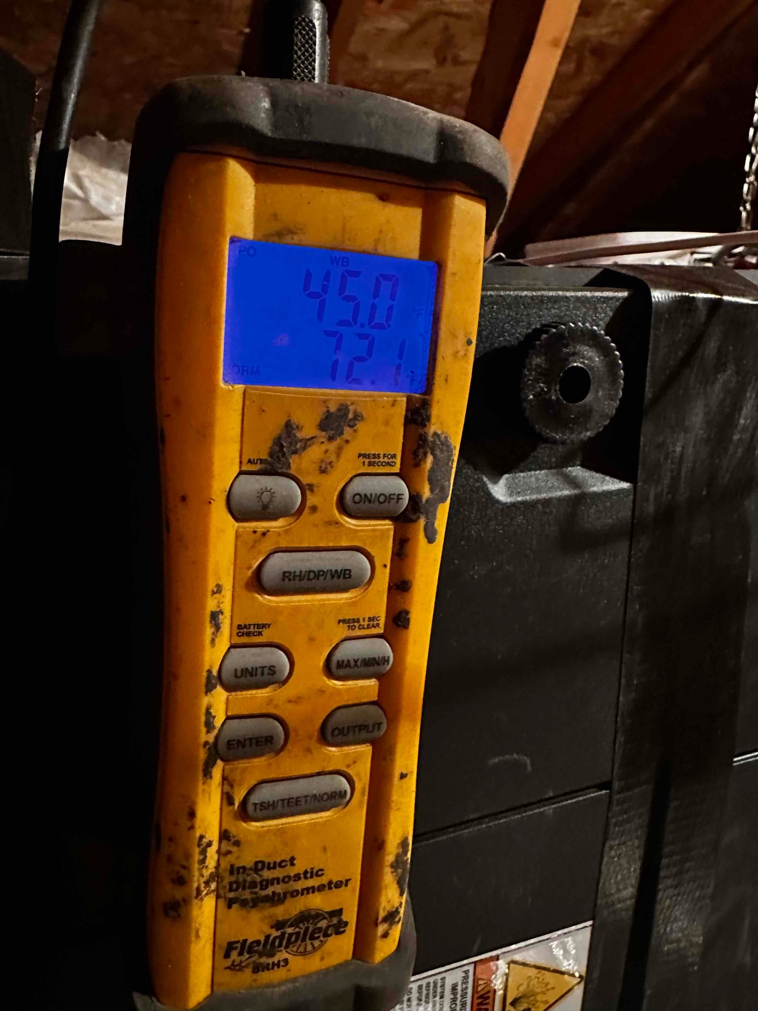 Digital in-duct thermometer displays 45.0 degrees and 72.1 degrees while measuring air temperatures during commissioning.
