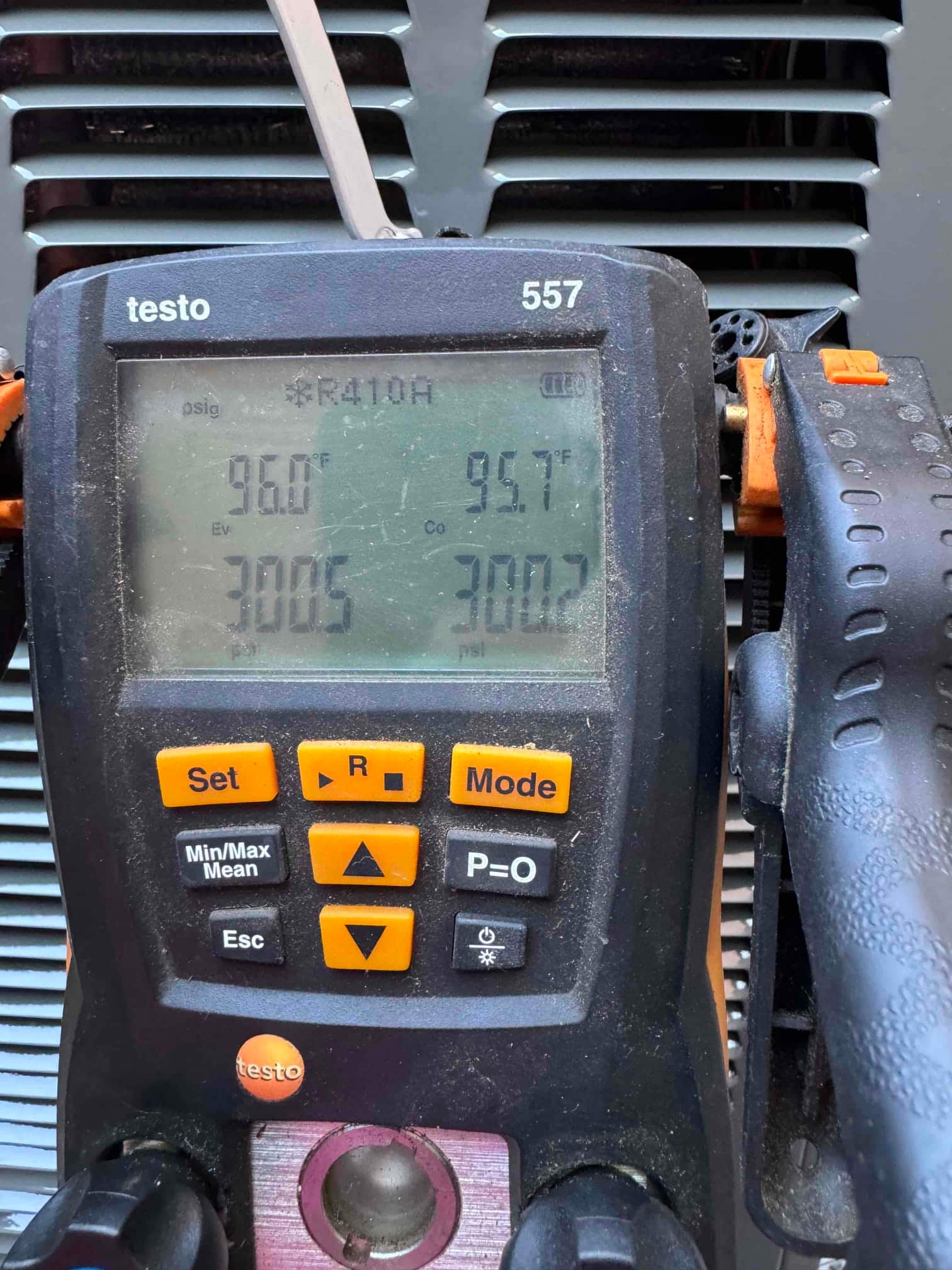 Digital manifold on the condenser shows operating pressures with R-410A selected during system commissioning.