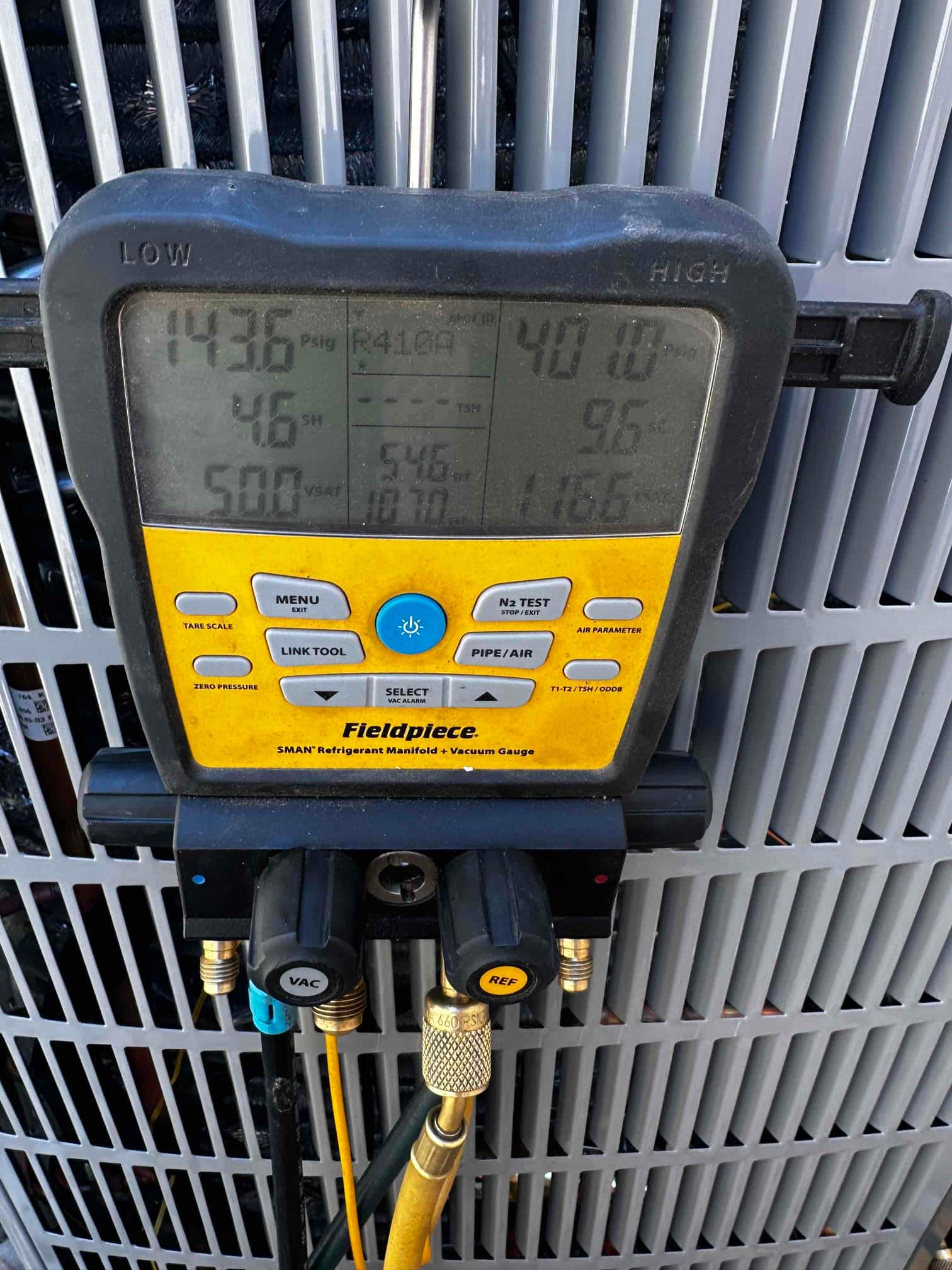 Digital manifold connected to the outdoor unit shows operating pressures of 144 psig suction and 401 psig liquid with R-410A selected.