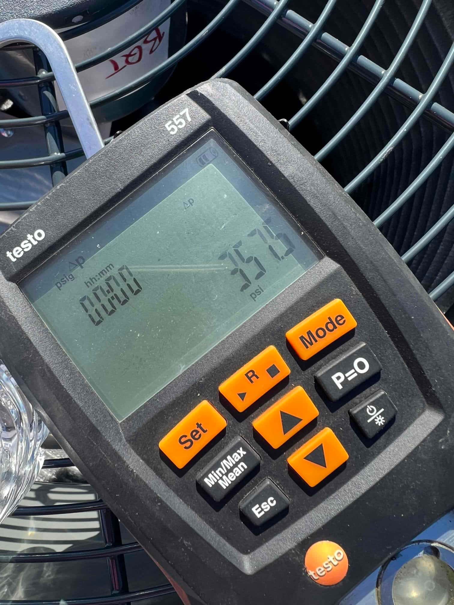 Digital manifold gauge displays 357 psi, documenting the nitrogen pressure test on the outdoor condensing unit.