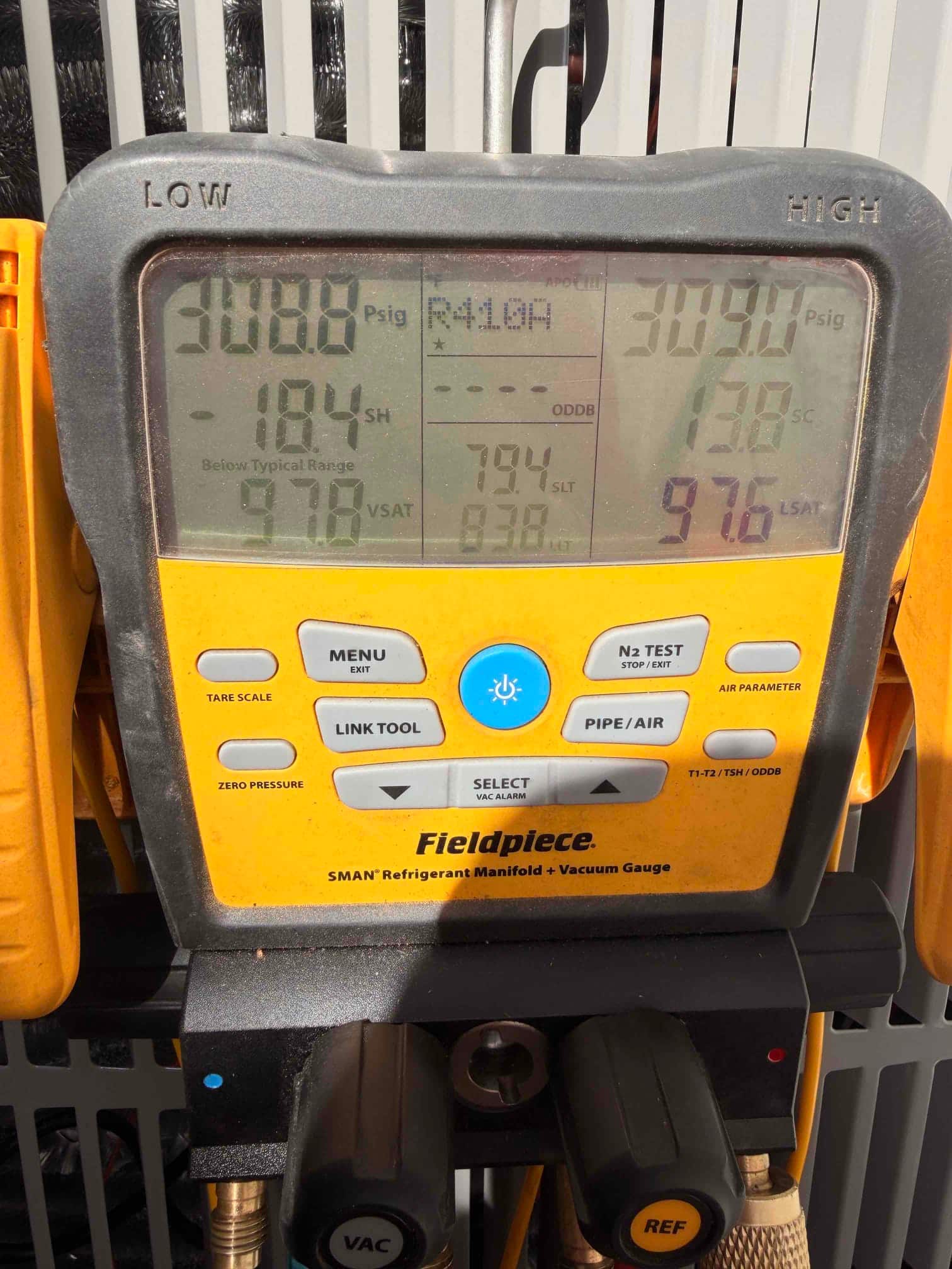 Digital manifold shows operating pressures with low side at 308.6 PSI and high side at 309.0 PSI during system commissioning.