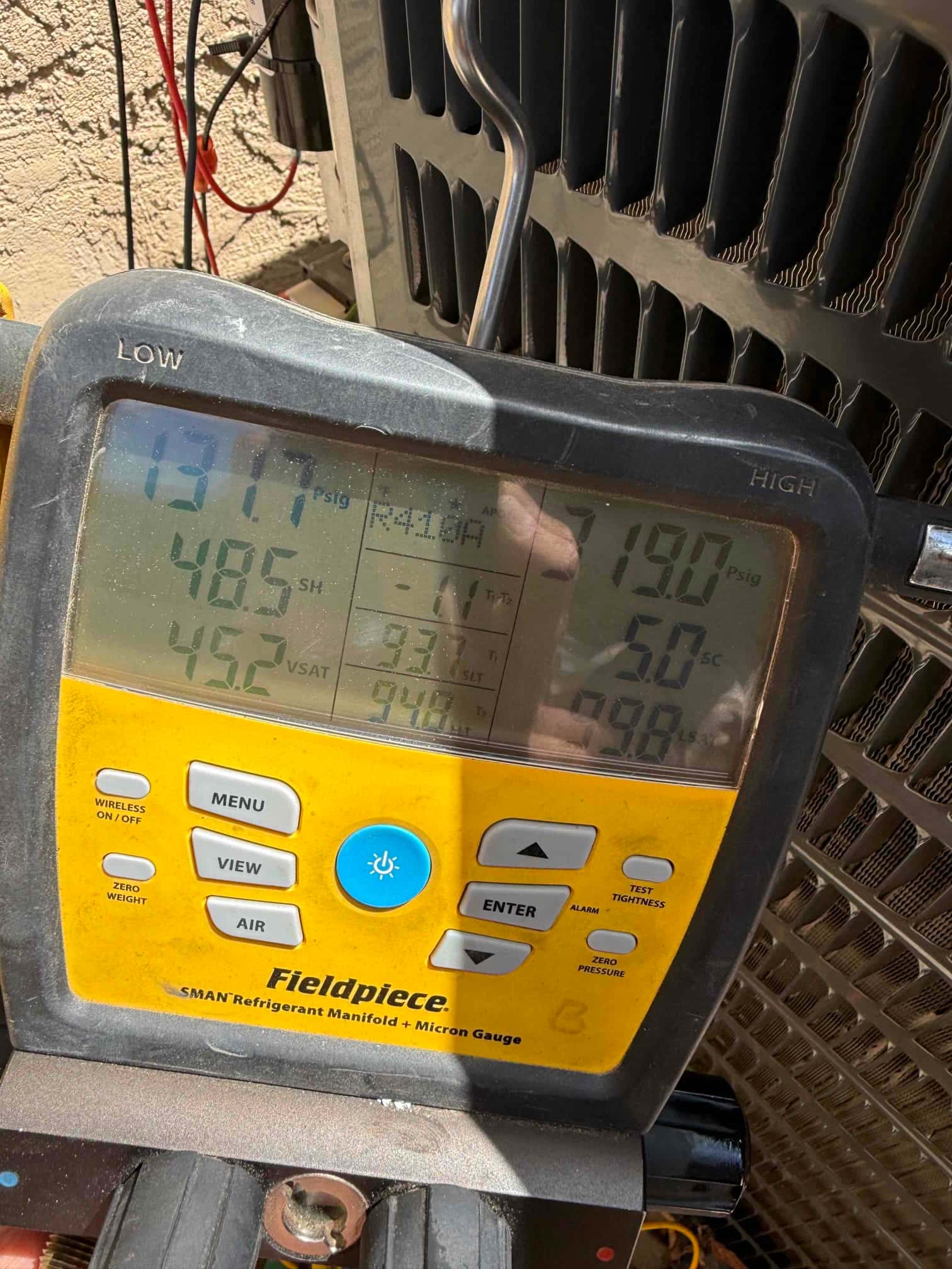 Digital manifold shows system operating with low and high side pressures alongside superheat and subcooling readings at the outdoor unit.