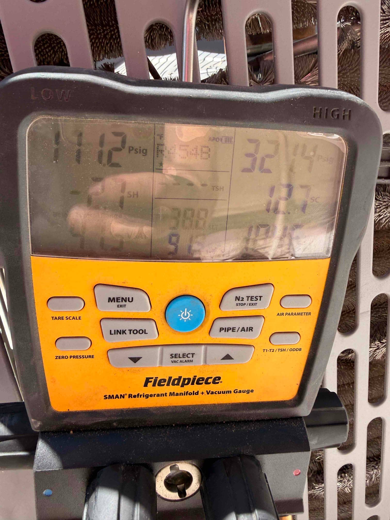 Digital manifold shows system operating pressures with R-454B selected, indicating active refrigerant commissioning on the outdoor unit.