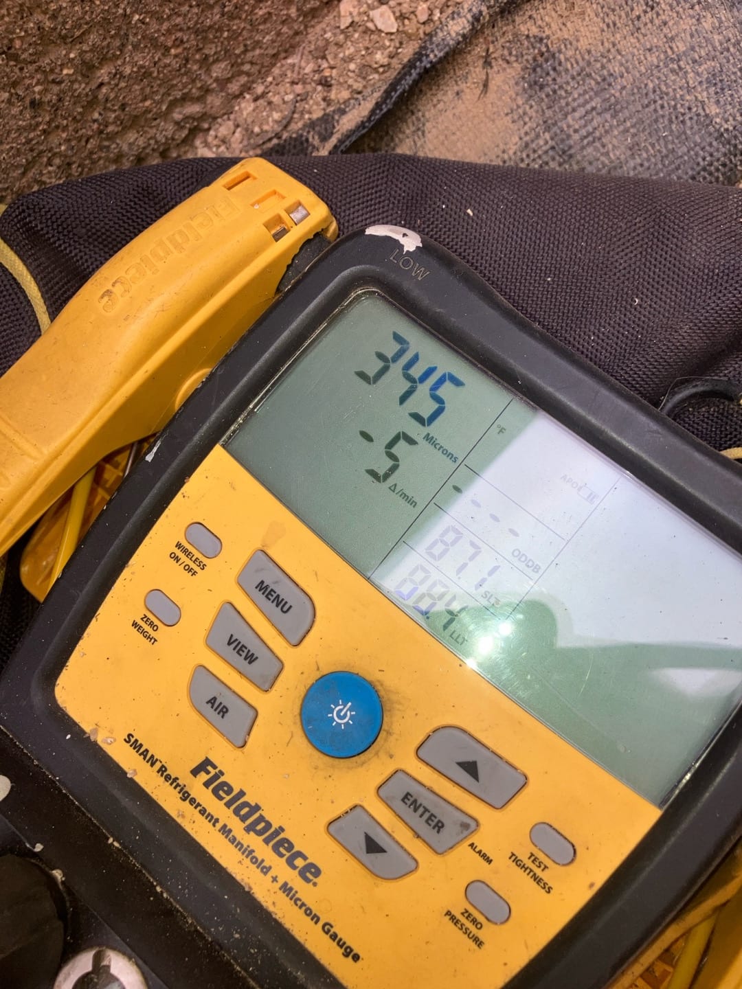 Digital micron gauge displays 345 microns during system evacuation, confirming a deep vacuum before releasing refrigerant charge.