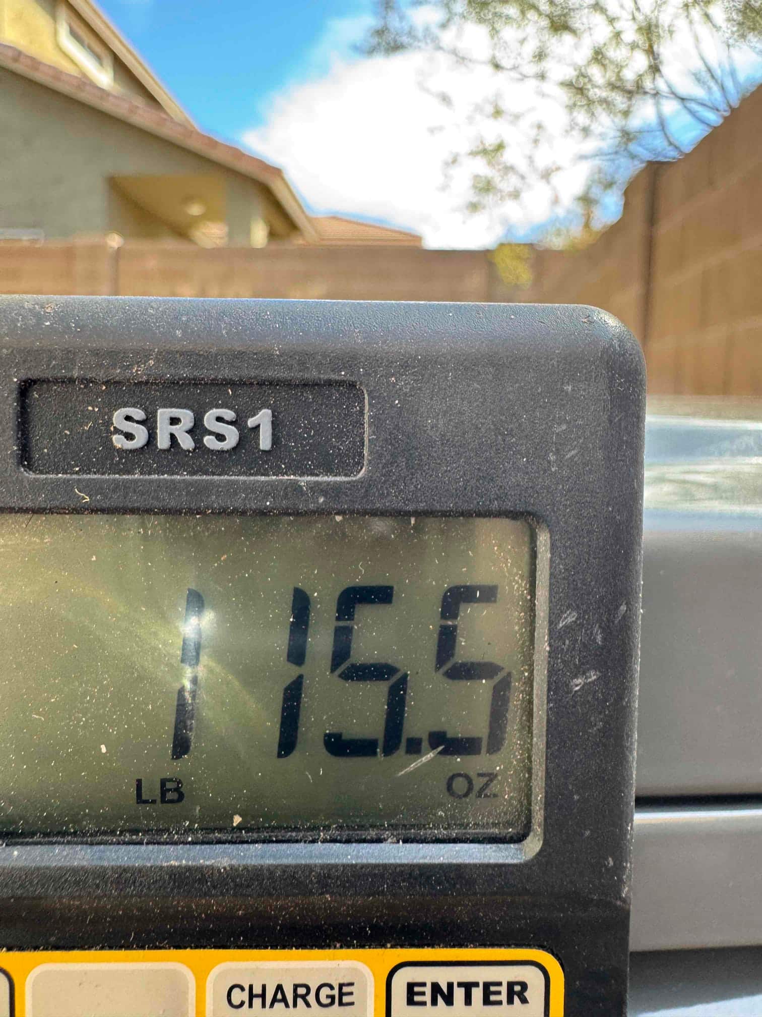 Digital refrigerant scale display shows a charge amount of 1 pound 15.5 ounces during system charging.