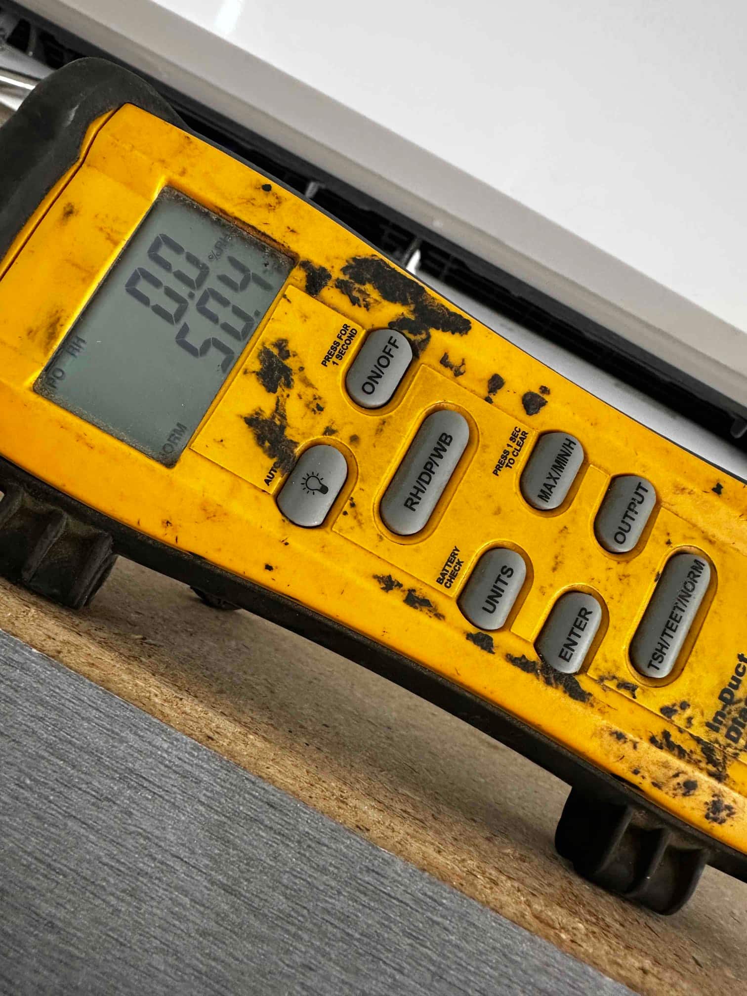 Digital thermometer displays 50.4 degrees Fahrenheit, documenting supply air temperature from the indoor mini-split unit.