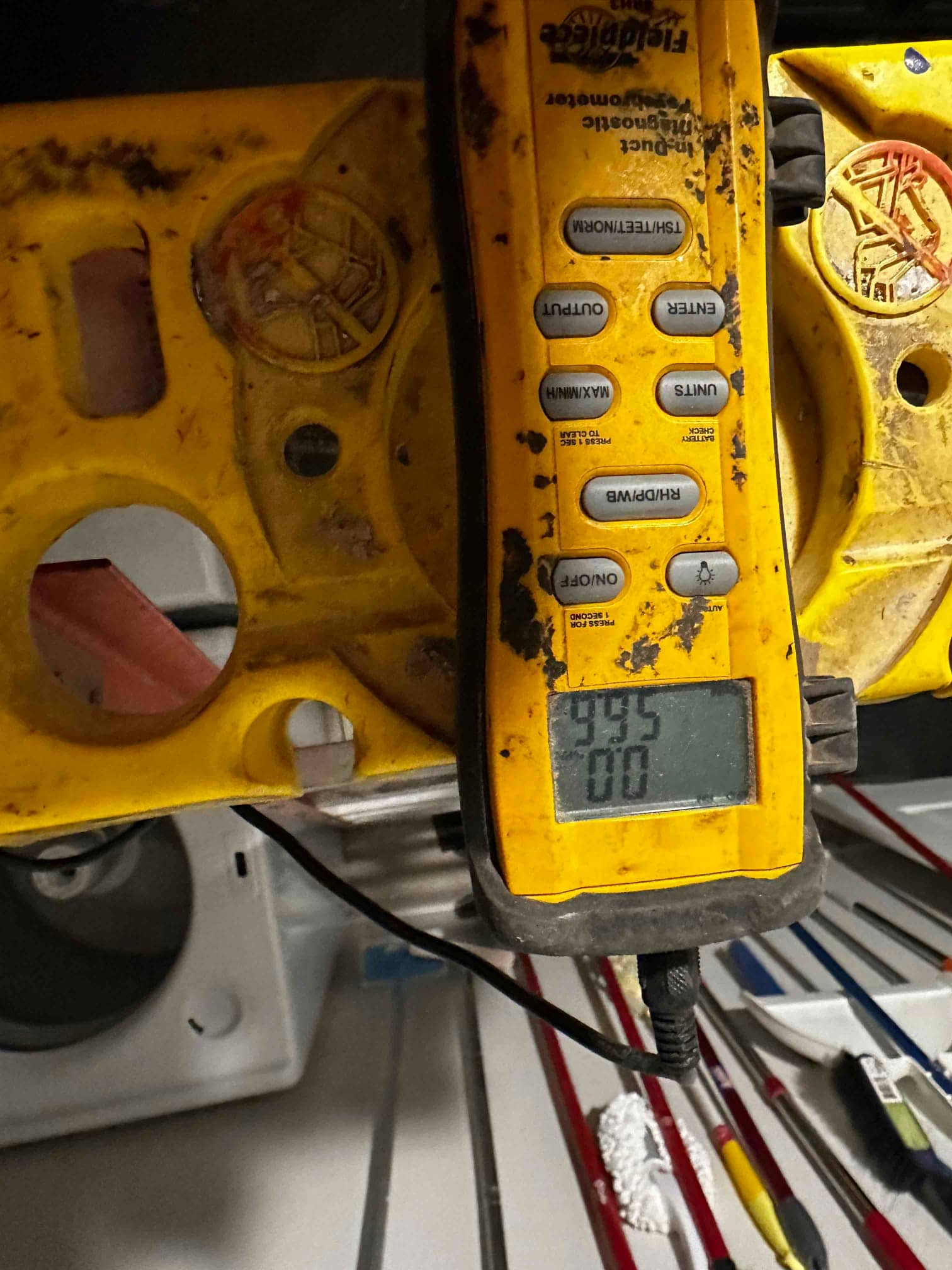 Digital thermometer with probe shows 95 on the display during air temperature checks at the HVAC system.