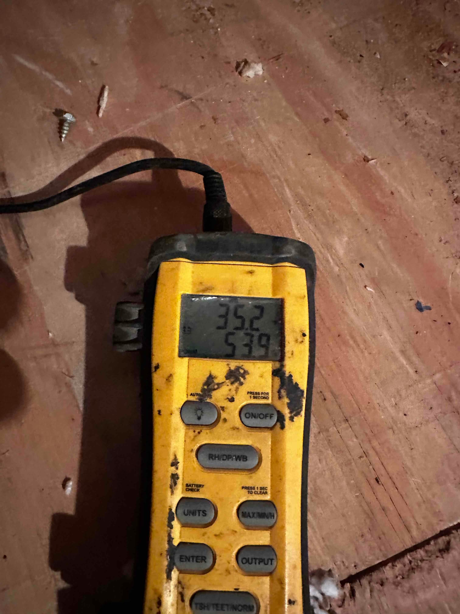 Digital thermometer shows 35.2 on the main display with probe connected during air temperature checks on the HVAC system.