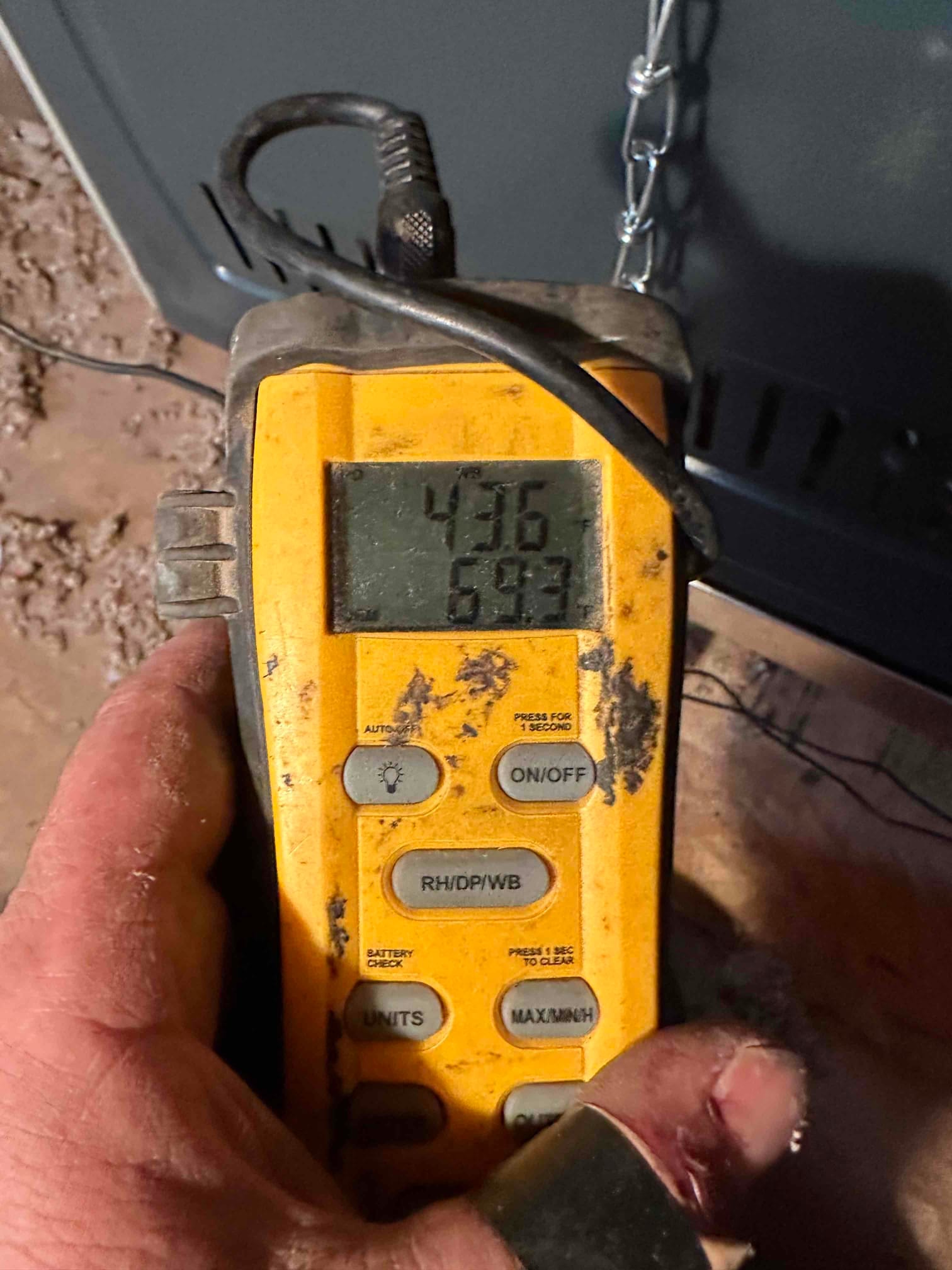 Digital thermometer shows 69.3 degrees Fahrenheit while measuring air temperature near the newly installed equipment.