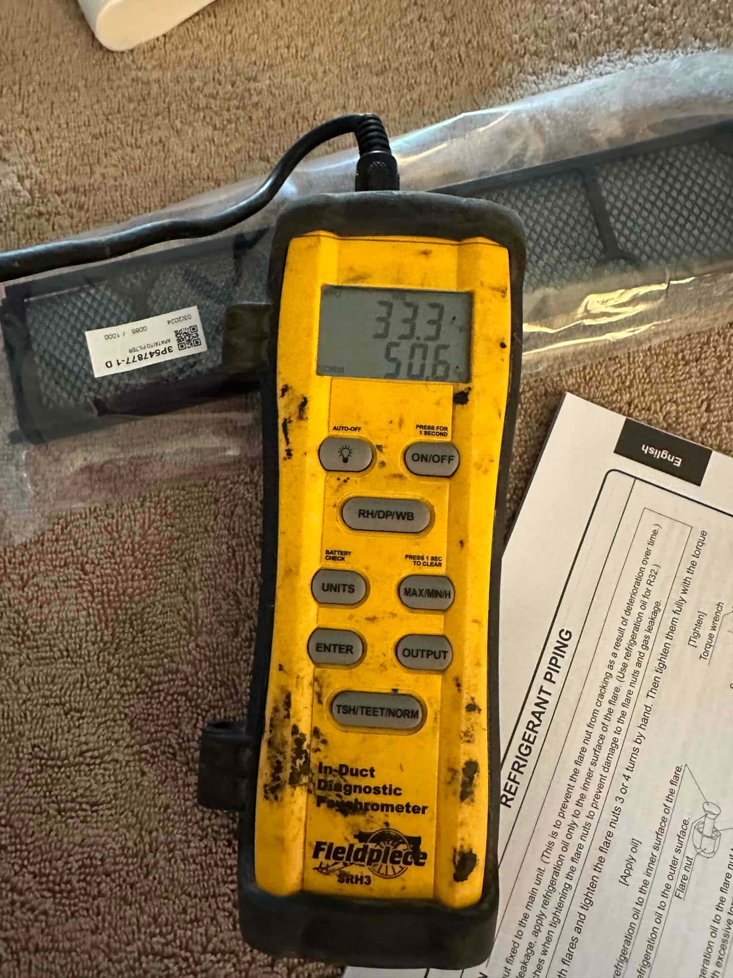 Digital thermometer shows a supply air temperature of 50.6 degrees Fahrenheit during commissioning of the mini-split system.