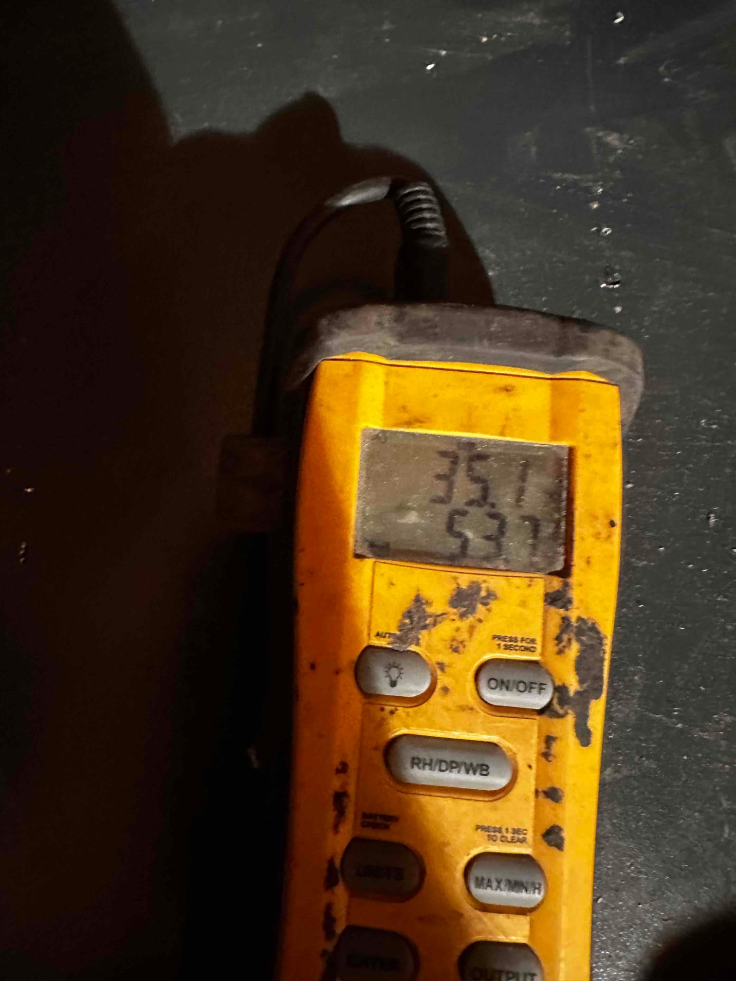 Digital thermometer shows two temperature readings on the display during air temperature checks at the HVAC system.
