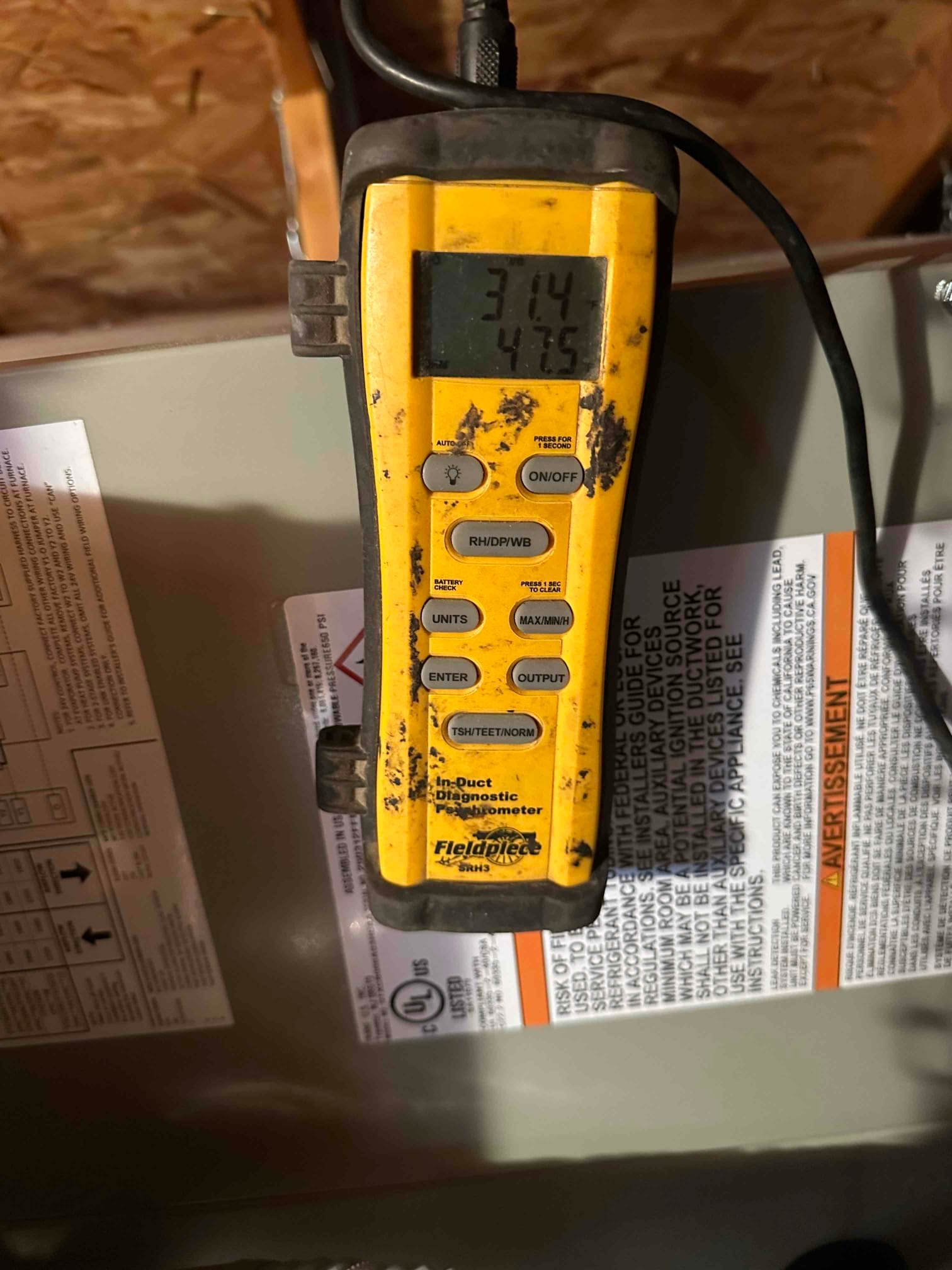 In-duct diagnostic manometer displays pressure readings during air-side commissioning on the newly installed system cabinet.