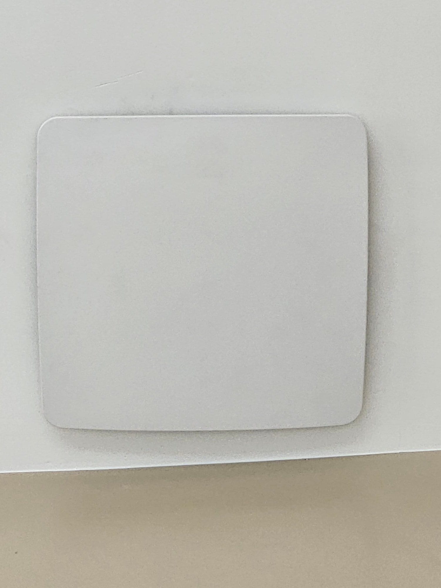 Flush-mounted wall sensor or thermostat cover installed on a finished interior wall during HVAC system installation.