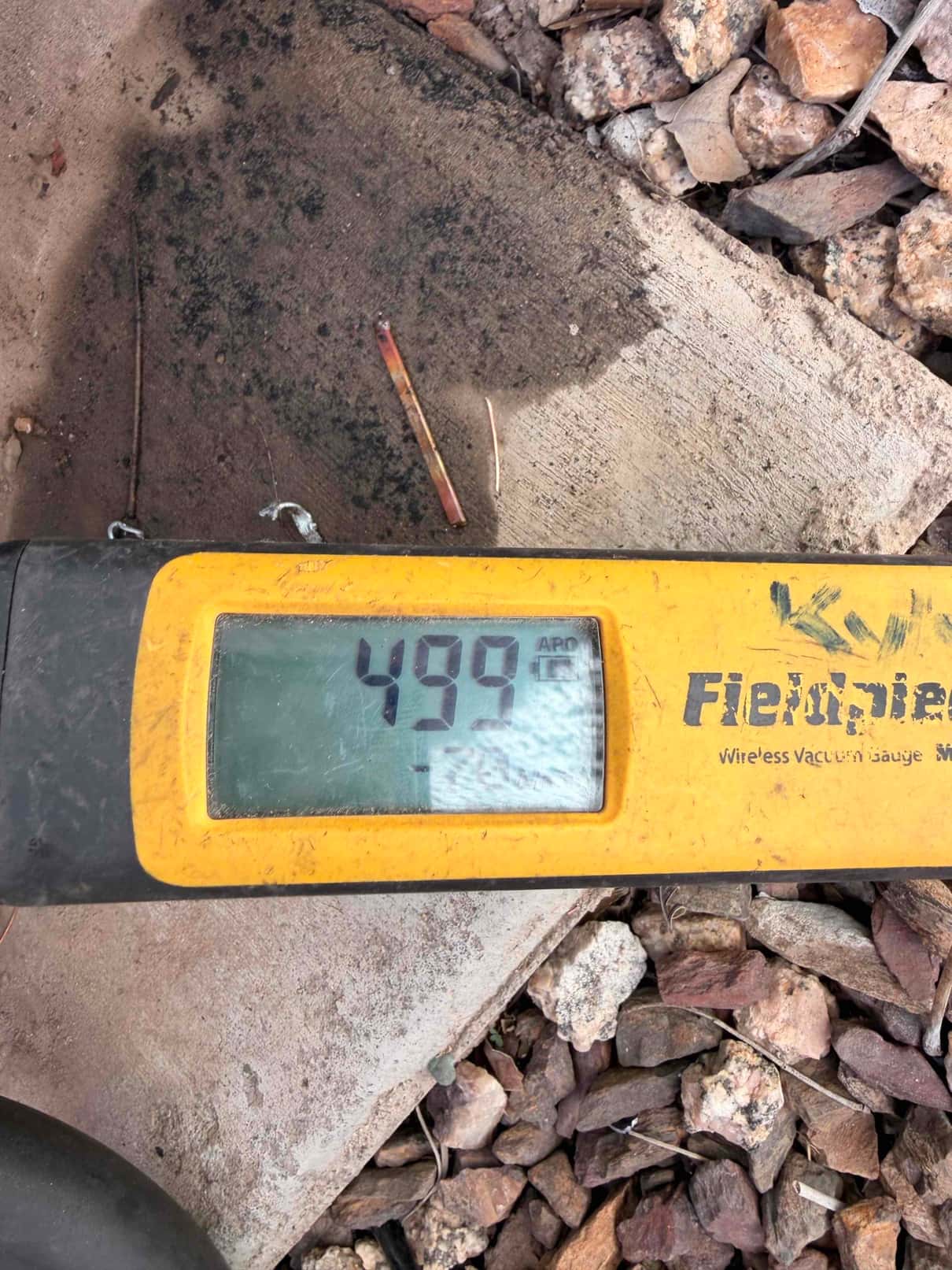 Micron gauge displays 499 microns during system evacuation, confirming a deep vacuum before opening the refrigerant charge.