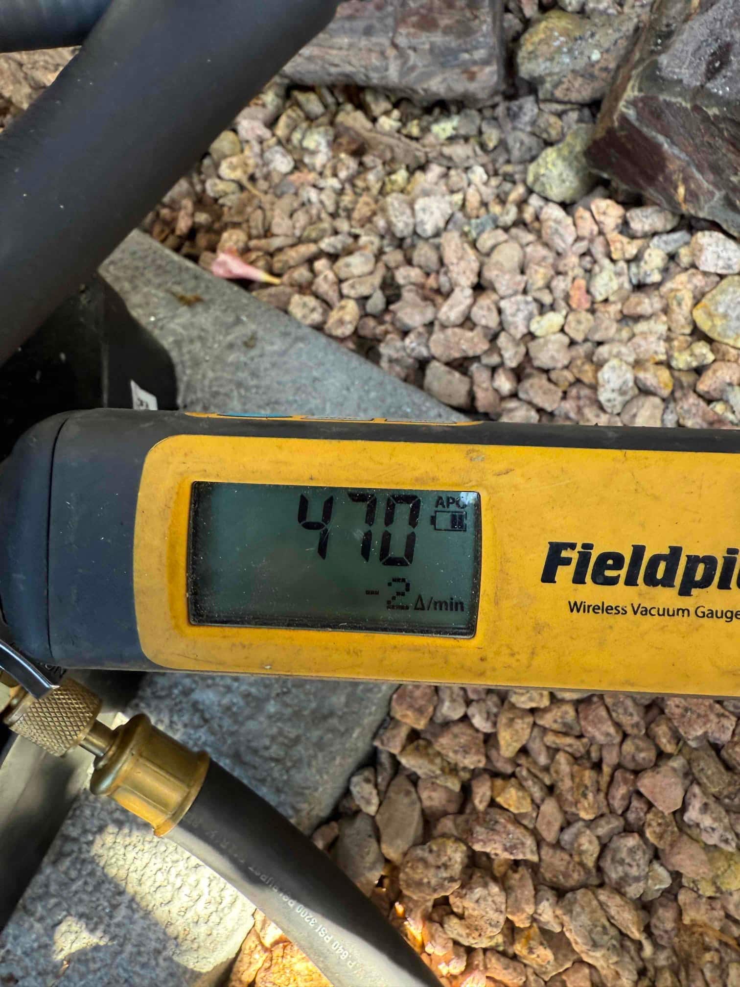 Micron gauge shows 478 microns during system evacuation, confirming a deep vacuum before releasing refrigerant into the lines.