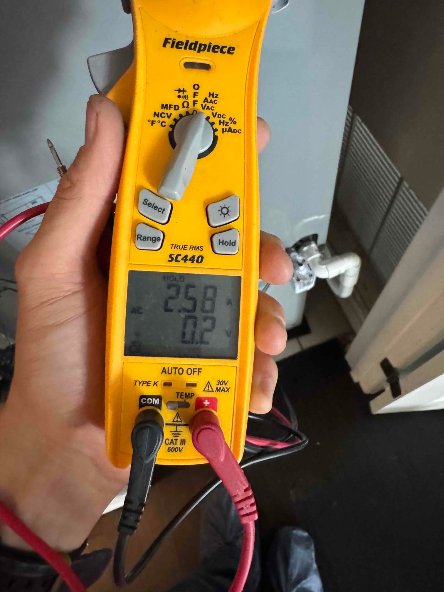 Multimeter measures 25.8 V at the condensate pump wiring near the air handler during drain line service.