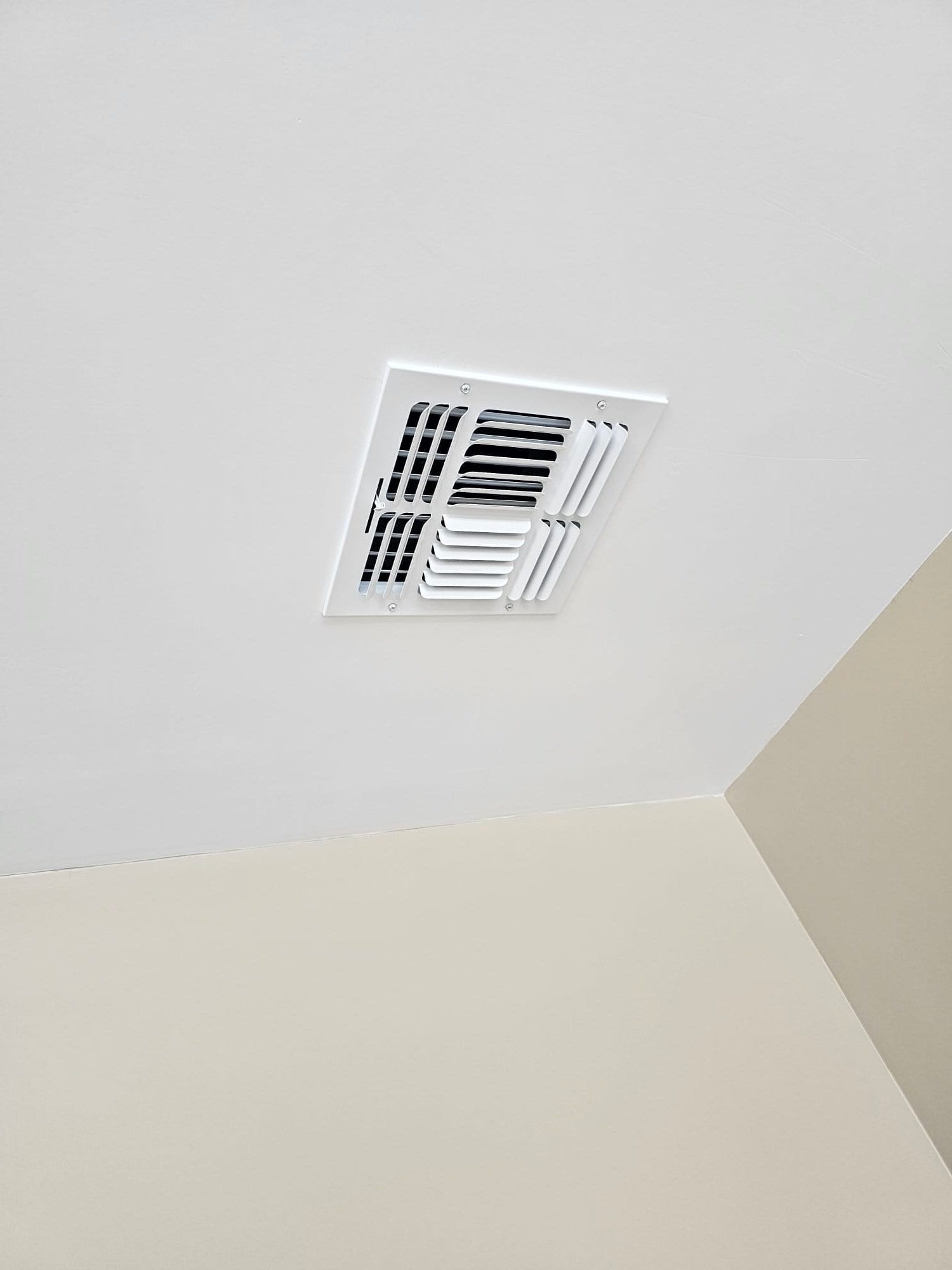 New ceiling supply register installed with clean trim and aligned louvers, showing finished duct termination at the room ceiling.