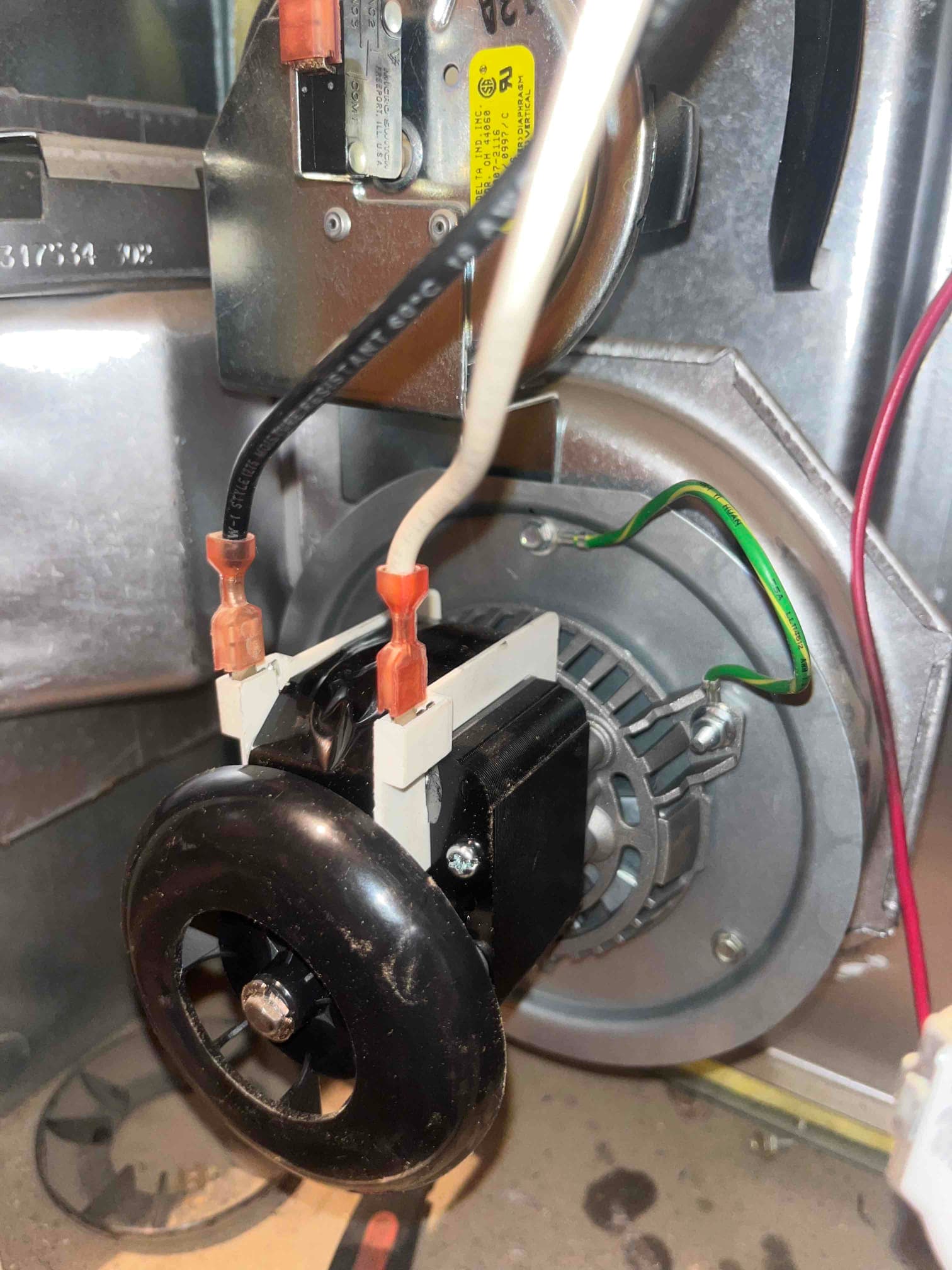 New inducer draft motor assembly installed on the furnace, showing wiring connections, blower wheel, and mounting bracket in clean condition.