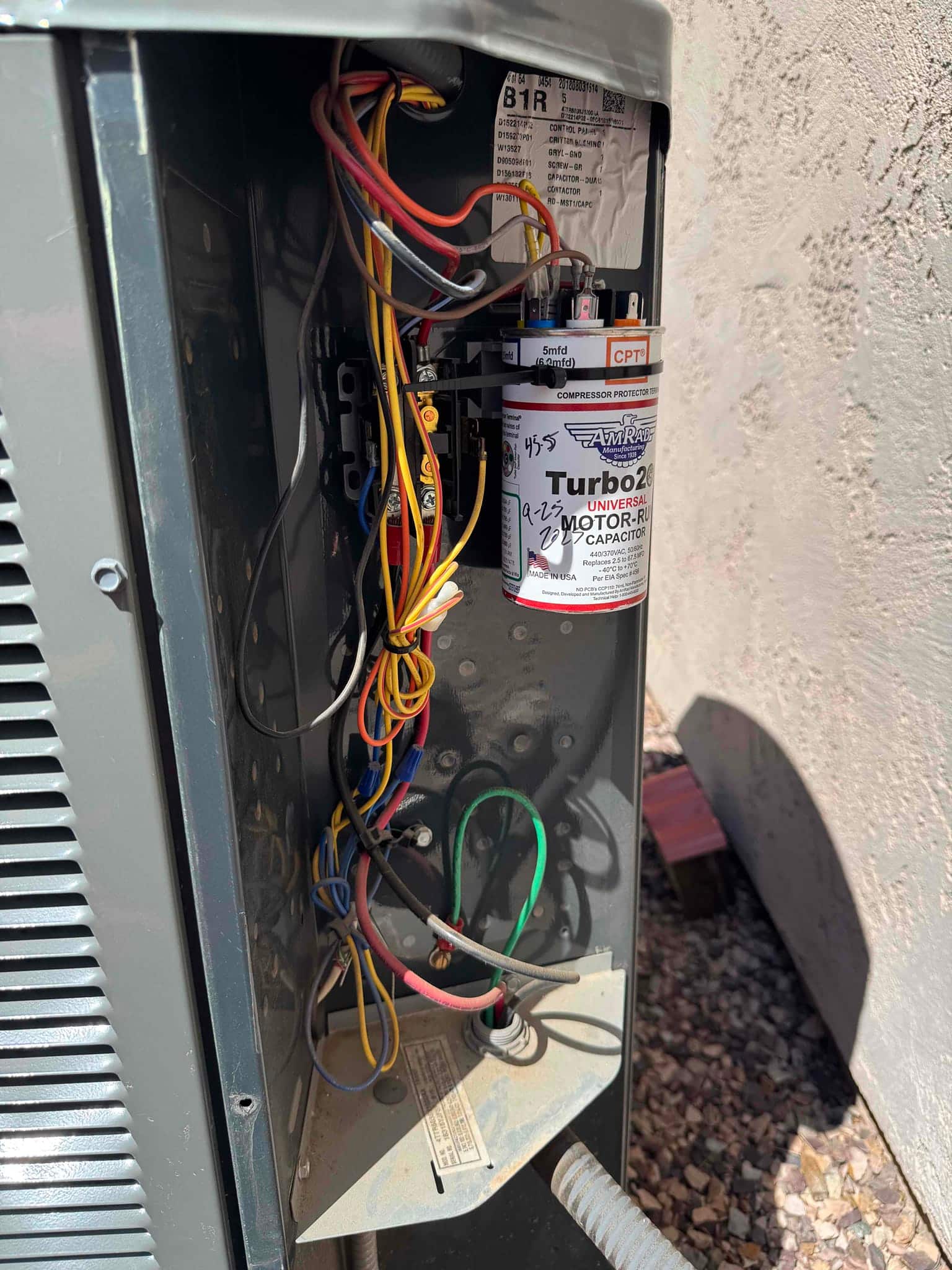 New Turbo 200 motor run capacitor installed inside condenser control panel, with connected wires and visible printed rating on the can.