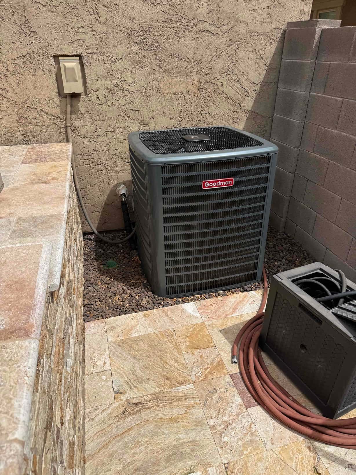 Outdoor condenser set on level surface with adjacent disconnect and insulated line set routed along the wall.
