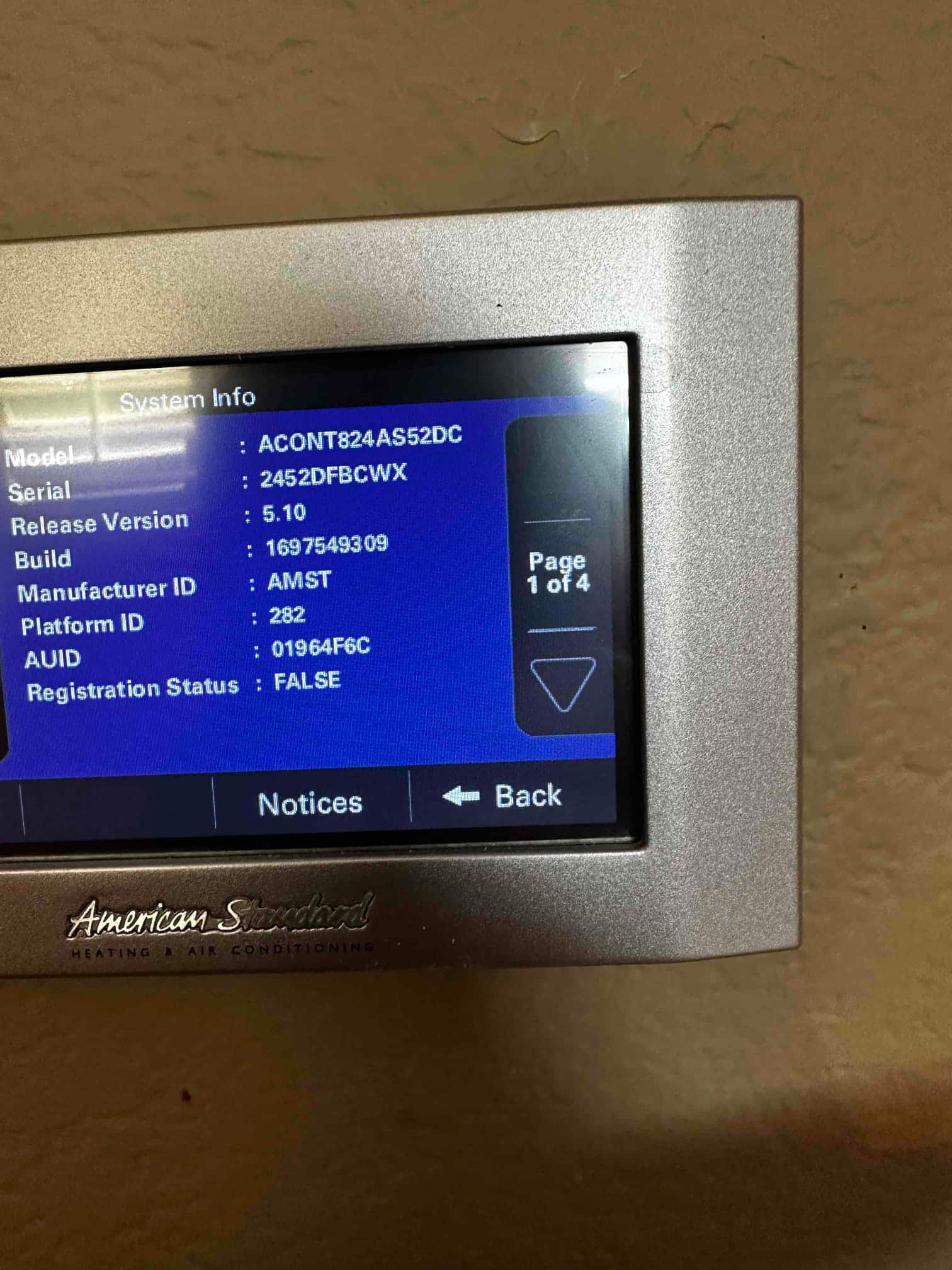 Thermostat displaying system information screen after installation, showing model details and software version on the wall-mounted controller.