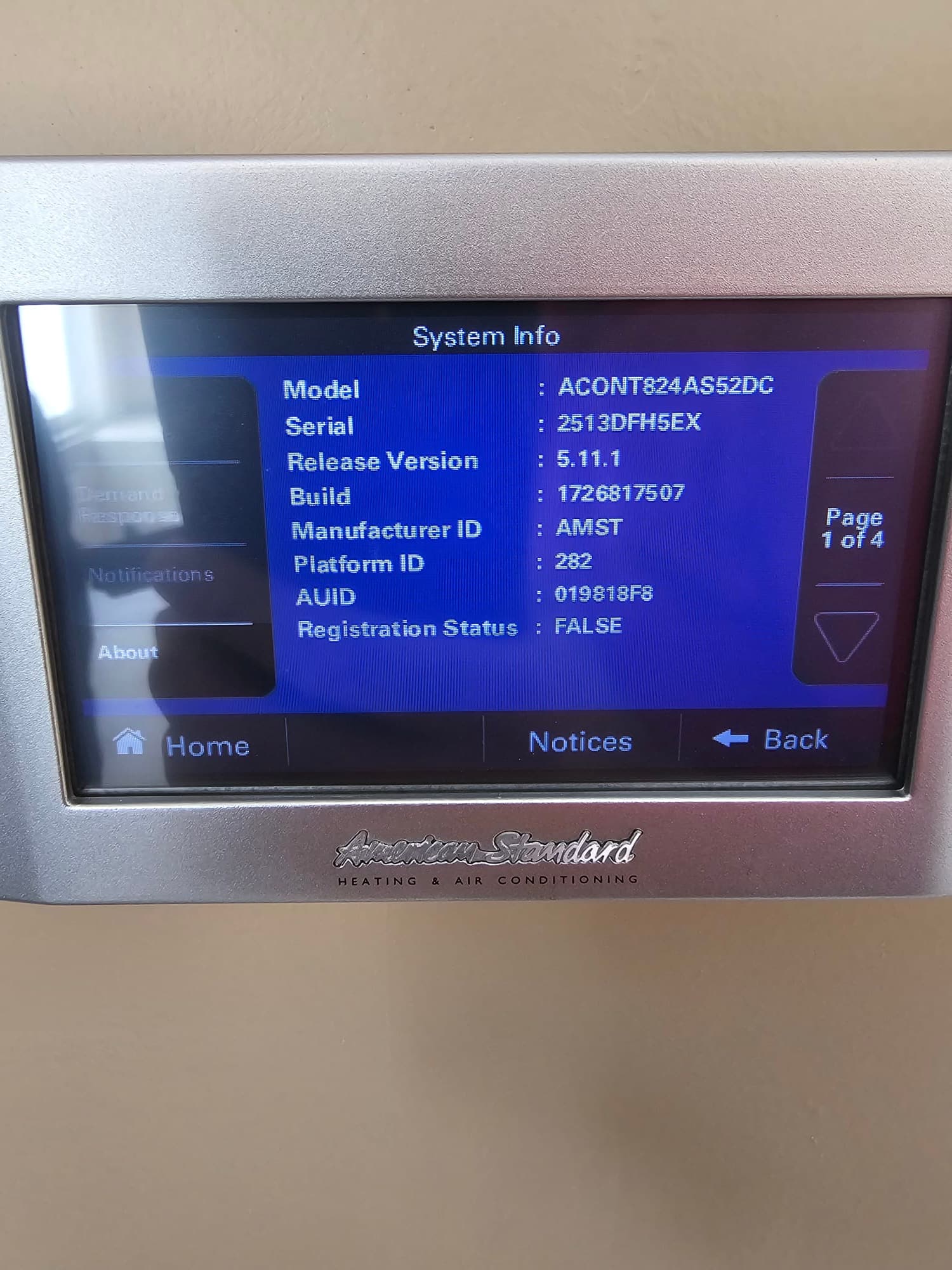 Thermostat touchscreen displays system information page with model, serial, software version, and identifiers after installation setup.