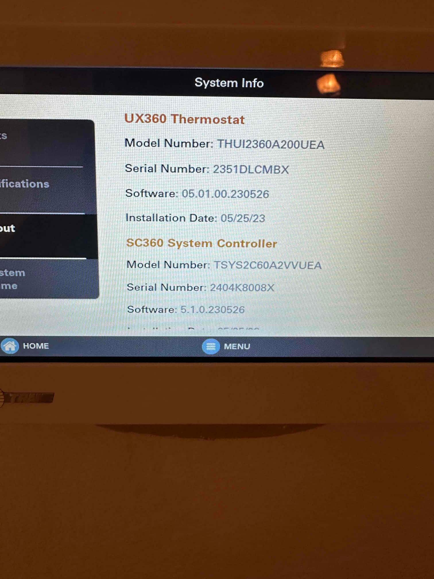 Thermostat touchscreen displays system information and software details after installation, showing model and serial entries on the interface.