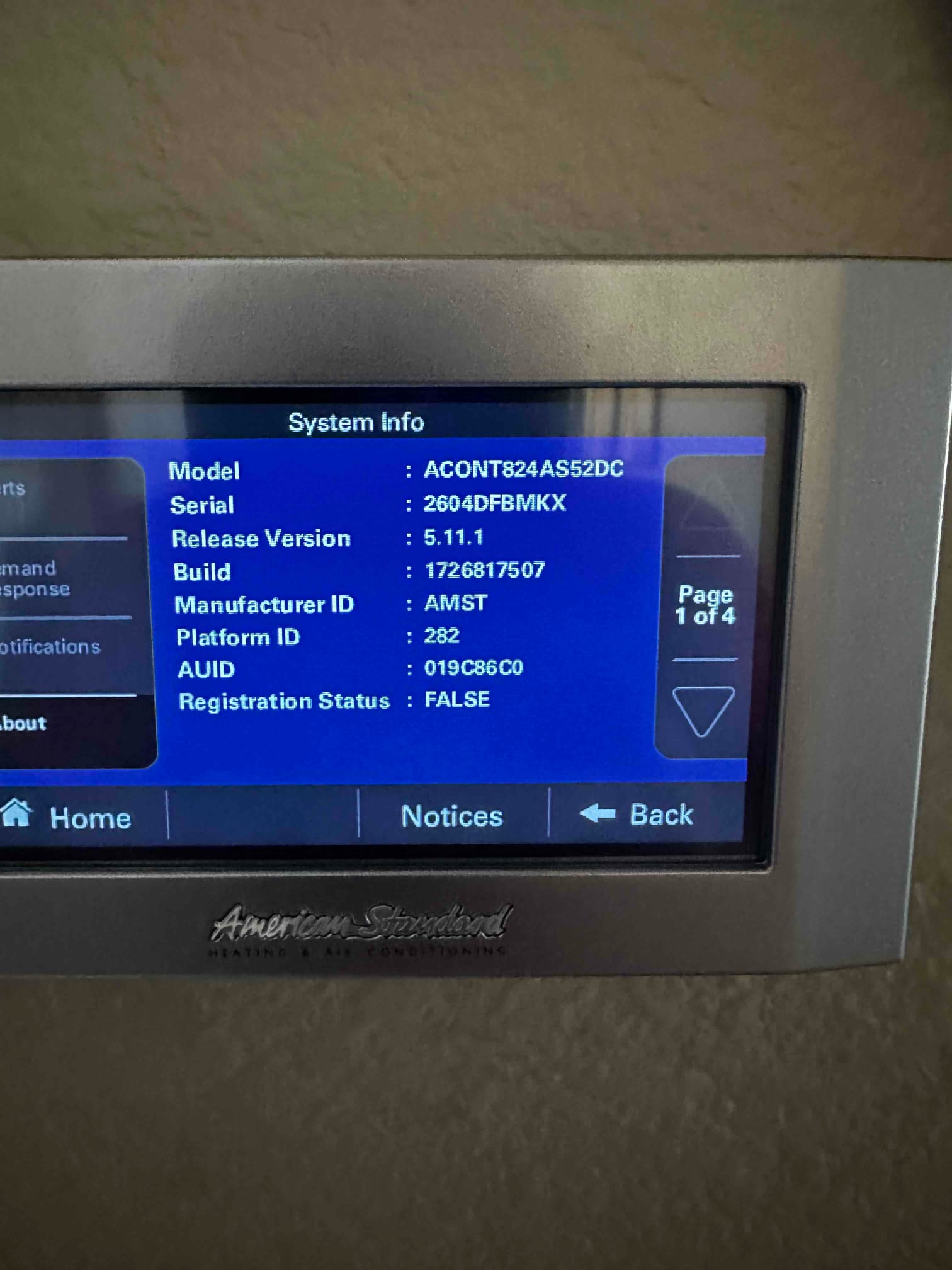 Touchscreen thermostat displays system information menu after installation, showing model, serial, software version, and status details.