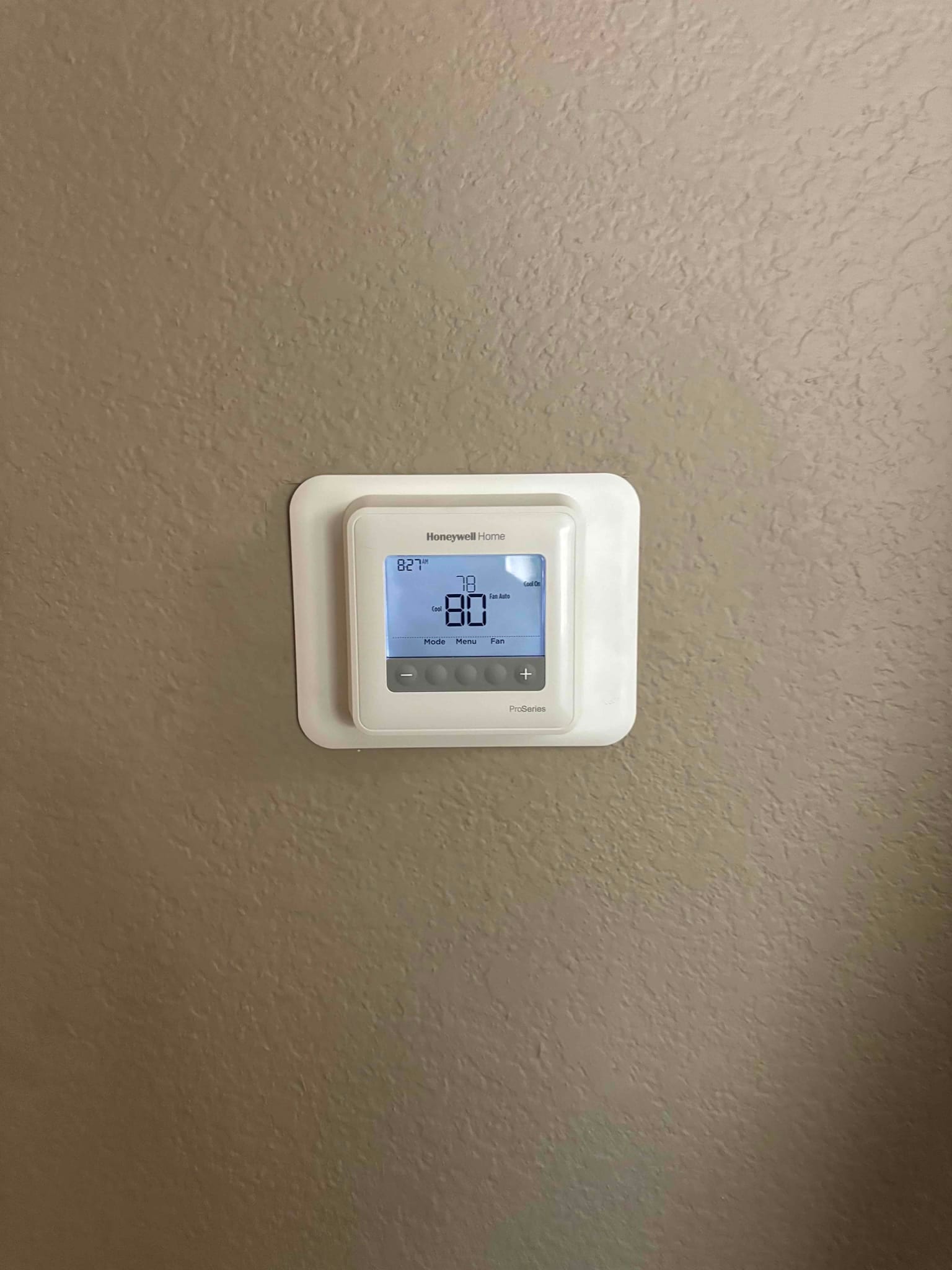 Wall-mounted digital thermostat installed and powered, showing cooling mode with a setpoint of 80 degrees.