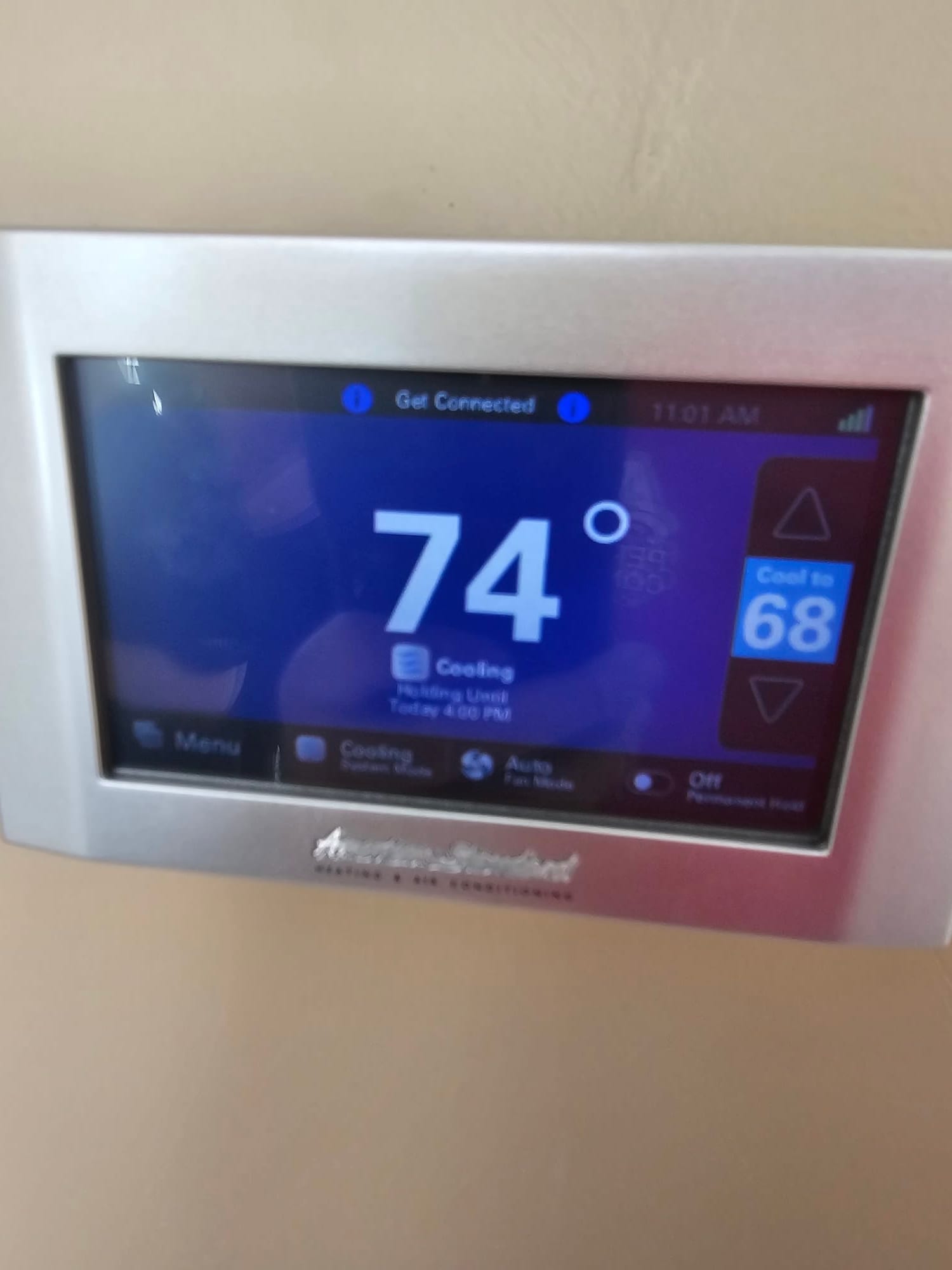 Wall-mounted thermostat displays indoor temperature of 74 degrees with cooling mode active and a setpoint of 68.