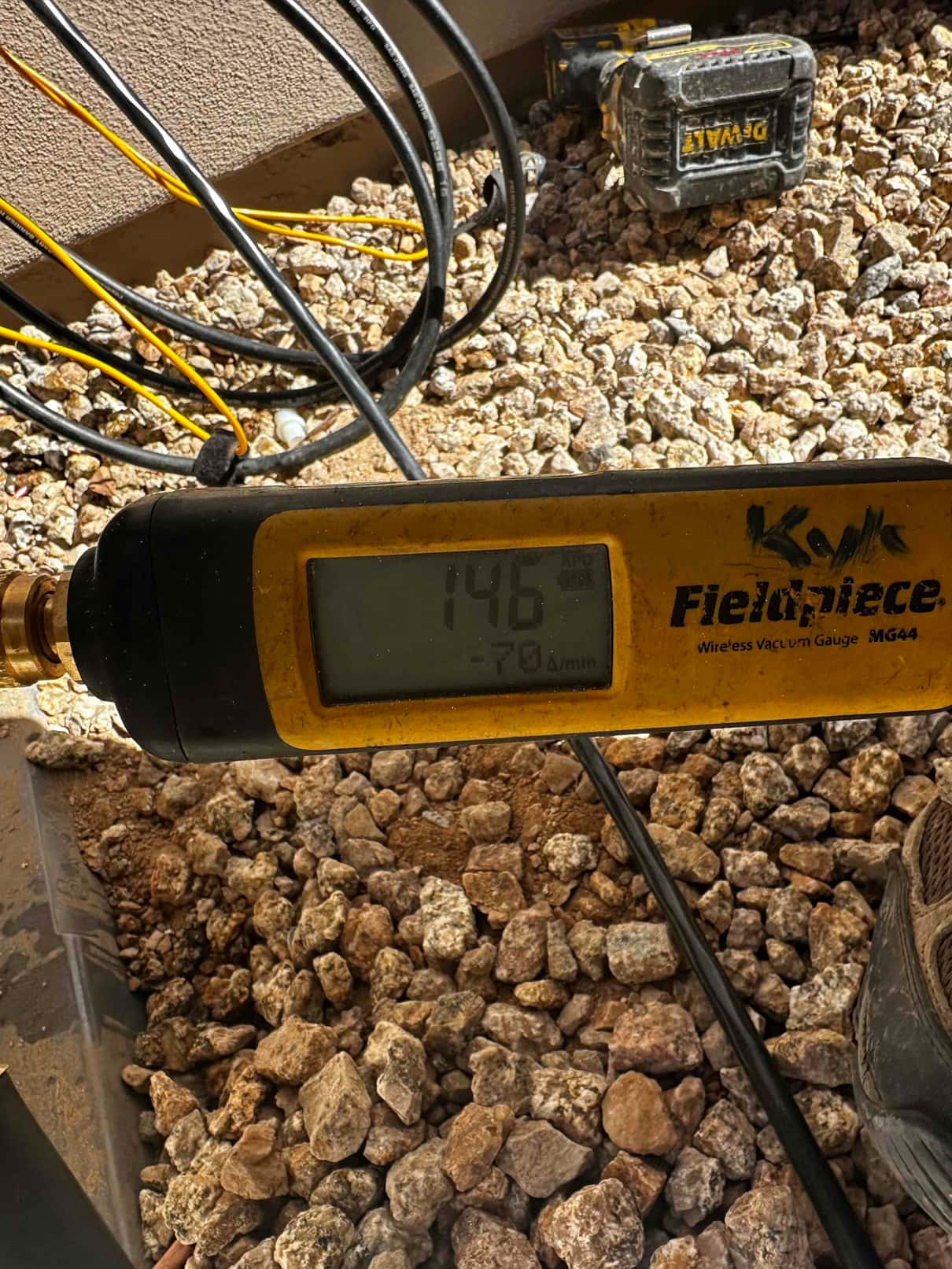 Wireless vacuum gauge shows 146 microns during system evacuation, confirming a deep vacuum before releasing refrigerant.