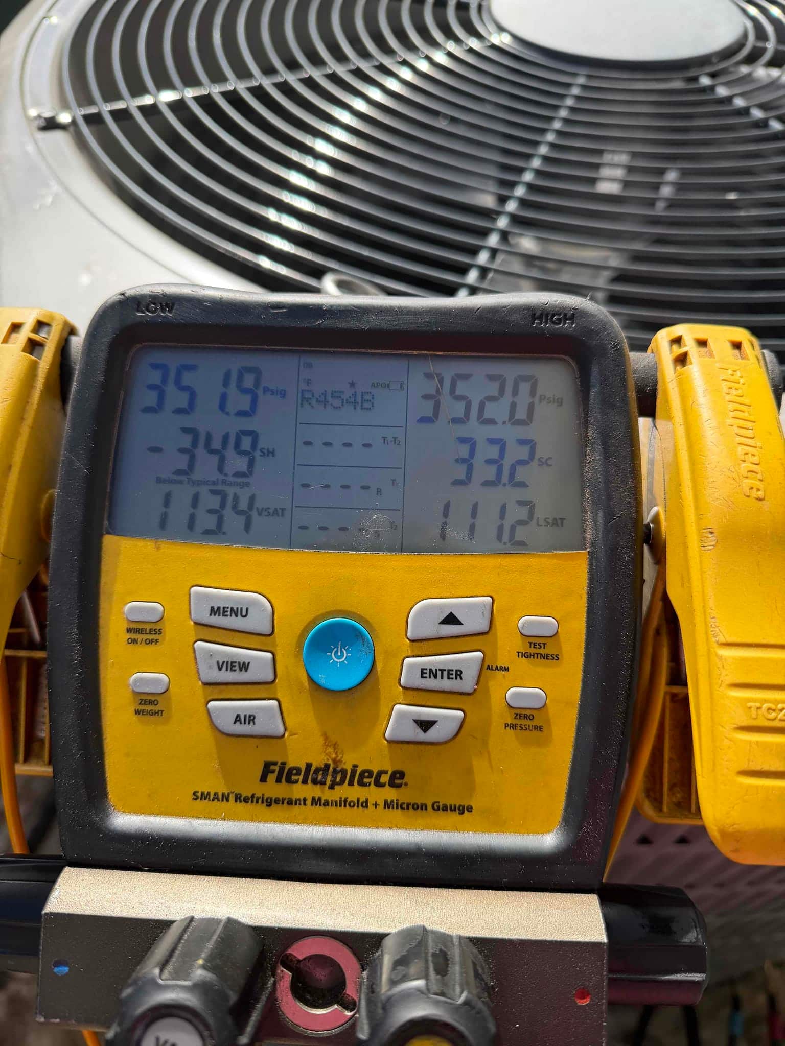 Digital manifold shows both sides holding around 352 PSI during a nitrogen pressure test at the outdoor condenser.