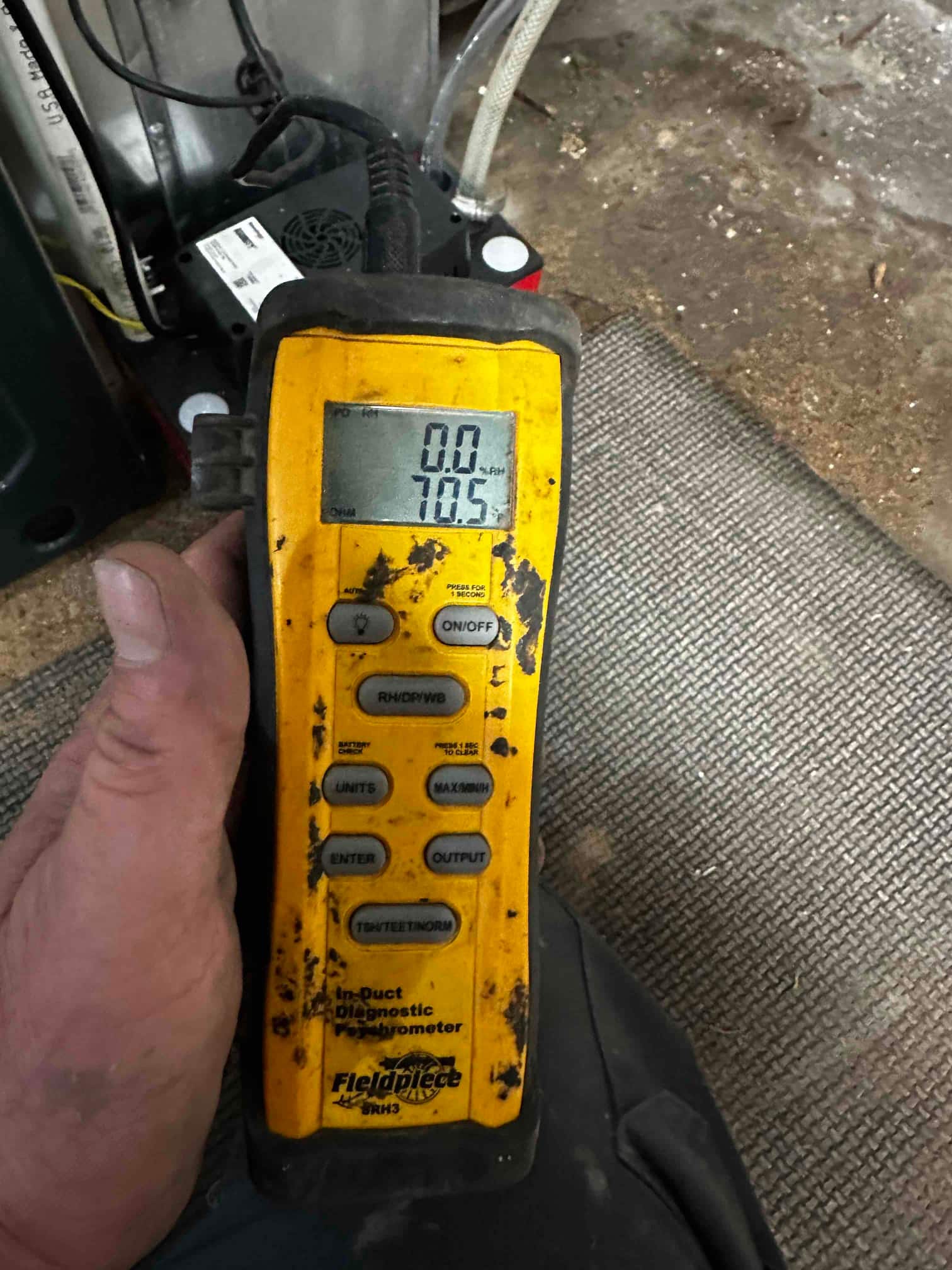Handheld digital thermometer displays 78.5 degrees Fahrenheit while measuring air temperature during system commissioning.