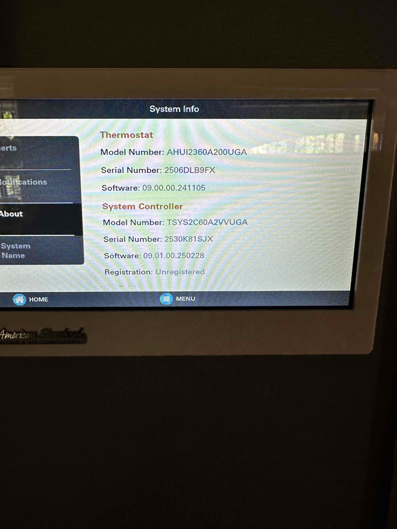Thermostat touchscreen displays system information for the thermostat and system controller with model, serial, and software versions.