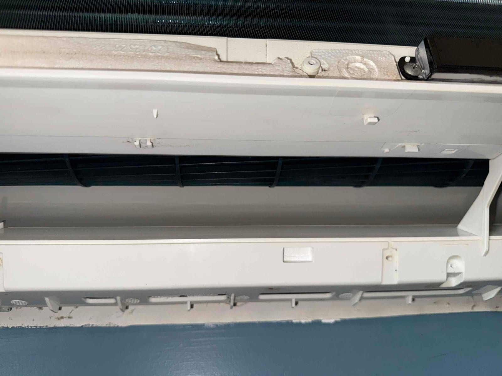 Mini-split indoor evaporator unit with front panel open, exposing the blower wheel and clean evaporator coil.