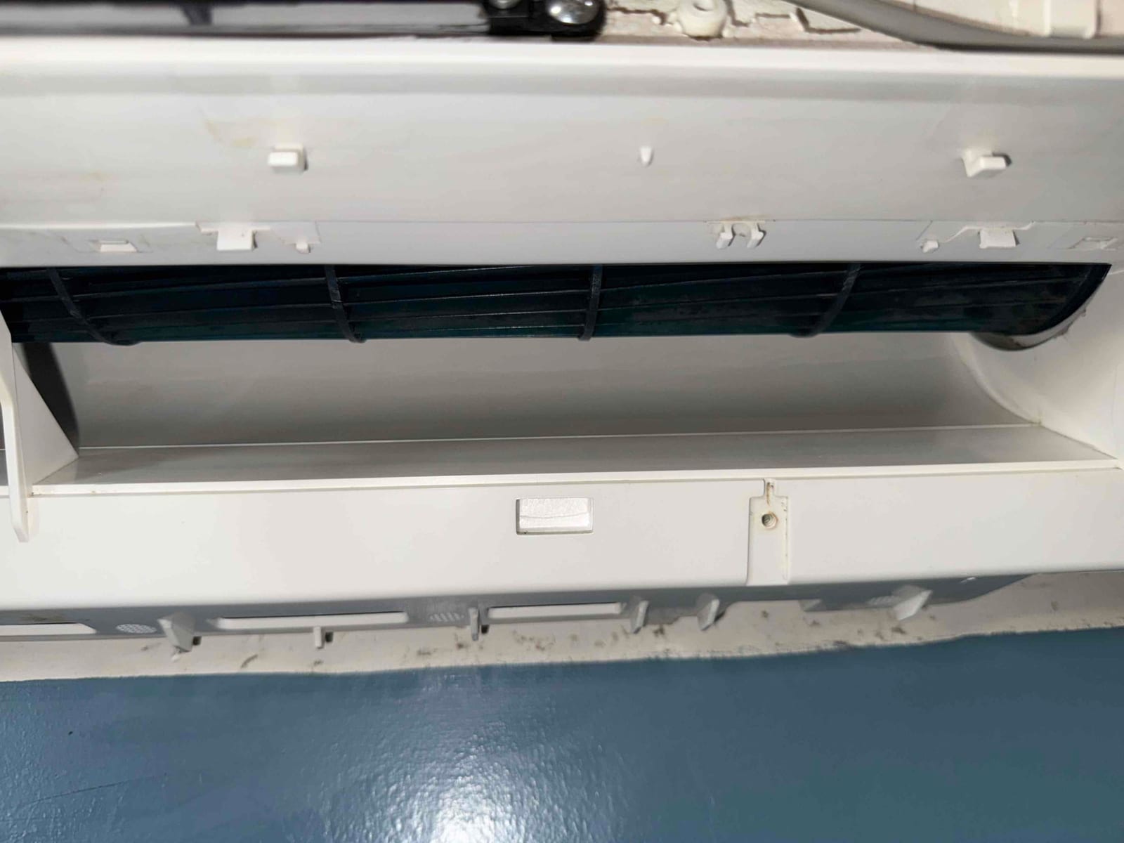 Mini-split indoor unit with front panel open, showing the clean evaporator coil and blower wheel after cleaning.