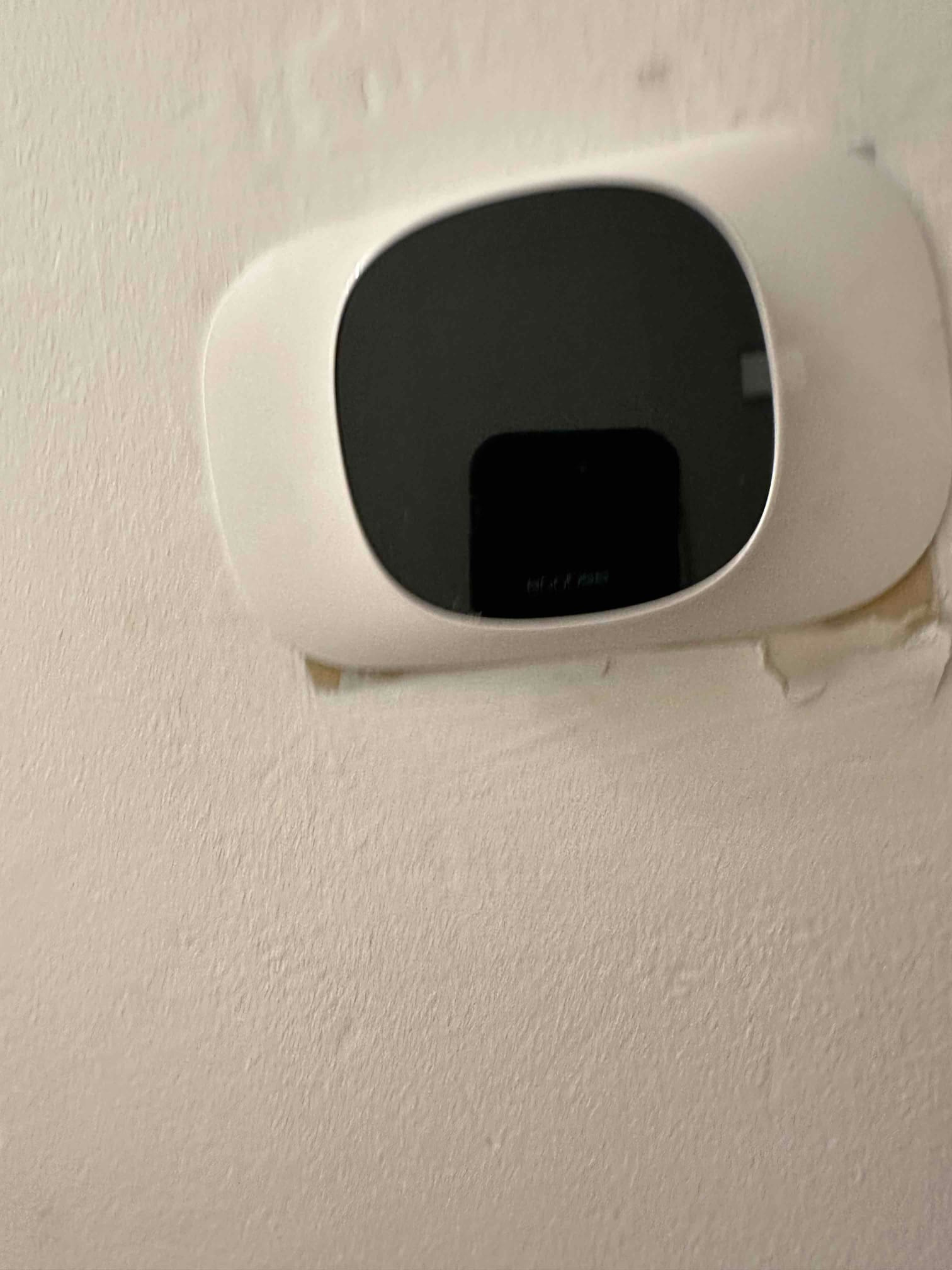 Wall-mounted smart thermostat installed on a finished wall, showing the control interface ready for system operation.