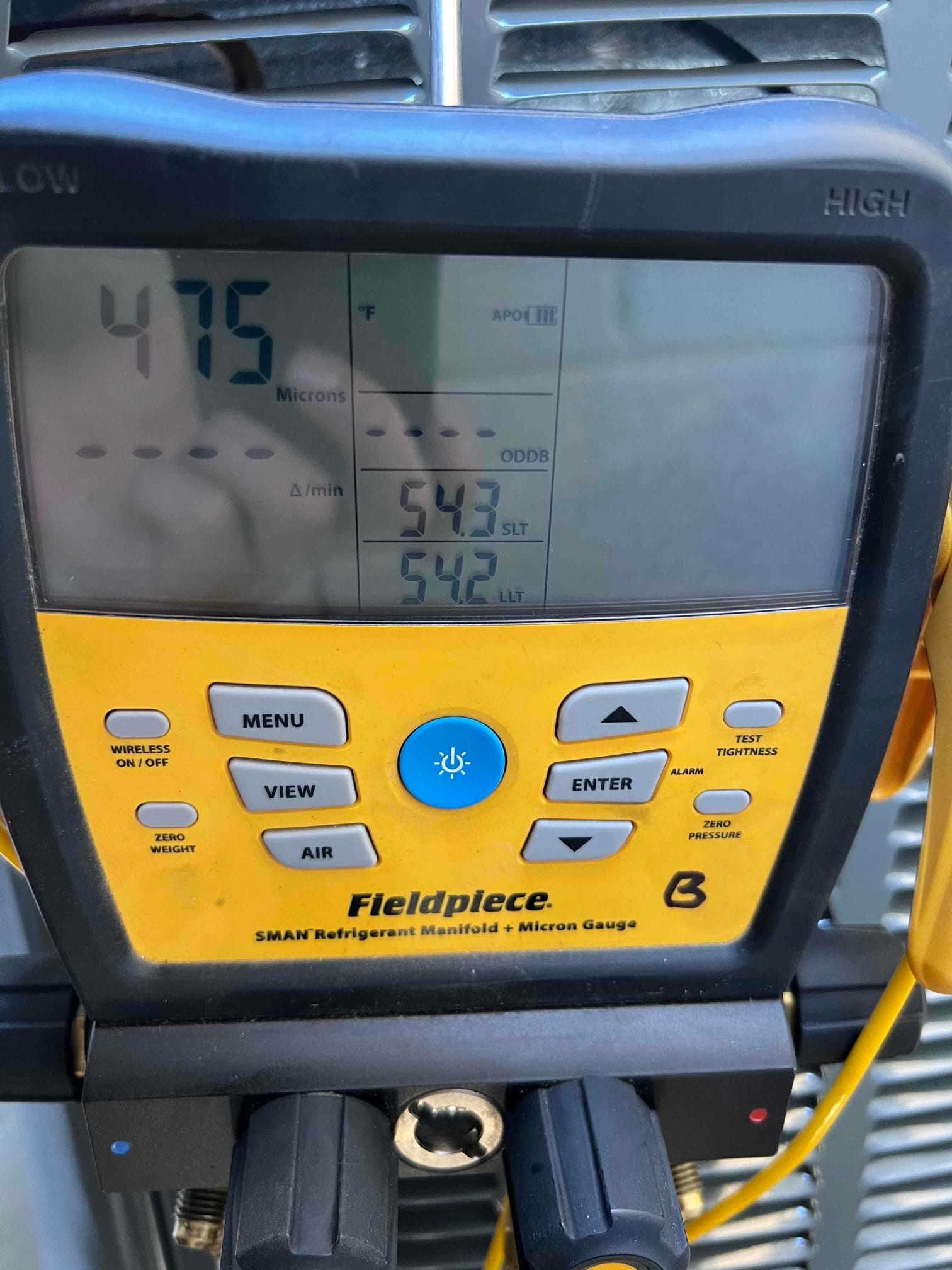 Digital micron gauge on the manifold displays 475 microns during system evacuation prior to refrigerant charging.