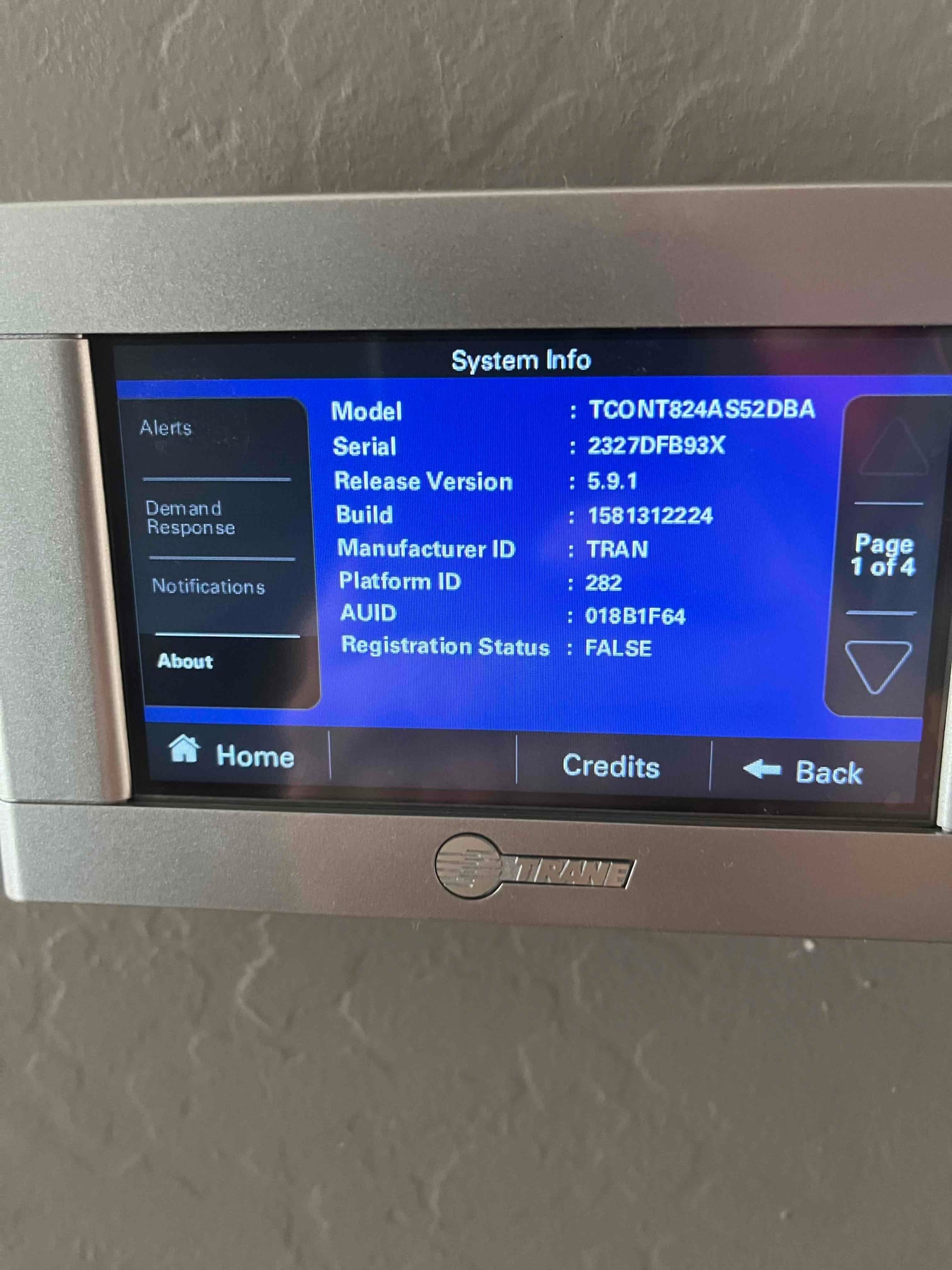 Wall-mounted HVAC thermostat displays system information screen with model and software details after installation.