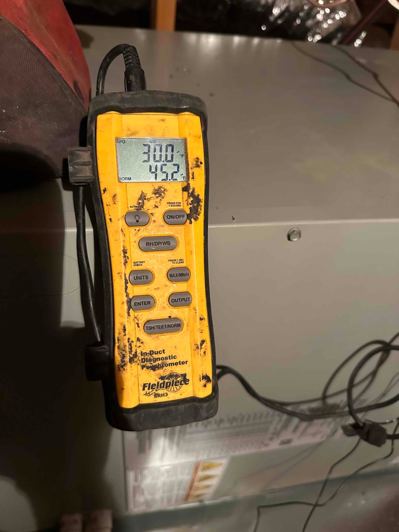 Digital in-duct thermometer/psychrometer displays 45.2 degrees, documenting air-side temperature during commissioning at the air handler.