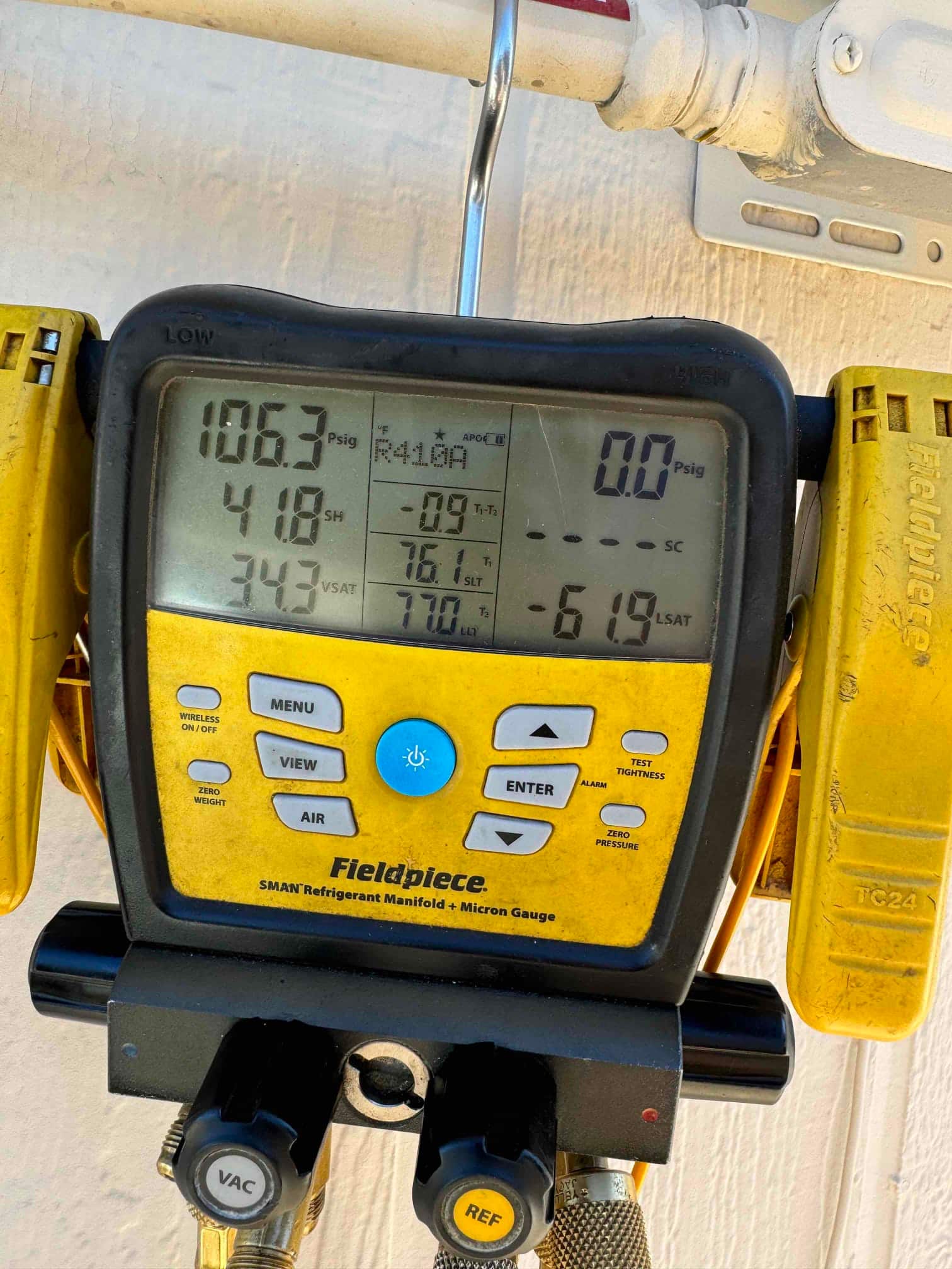 Digital manifold shows system operating with low side at 106 psig and high side at 418 psig on an HVAC install.
